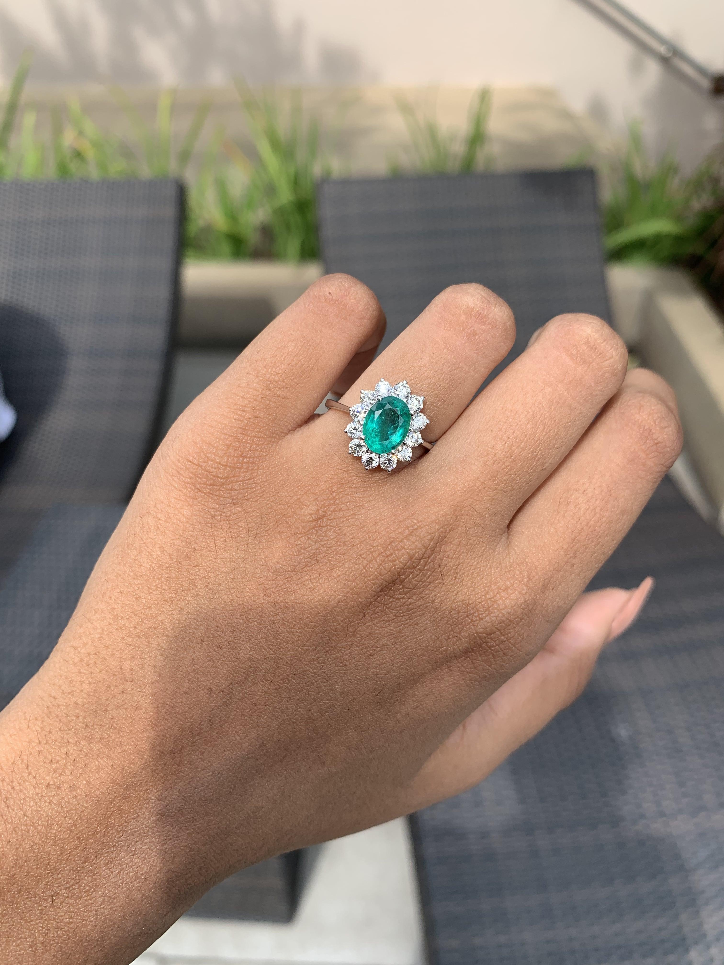 Presenting this dainty ring that perfectly combines the vivid green elegance of a meticulously cut emerald with the brilliance of sparkling round Diamonds.

Originating from the enchanting mines of Zambia, the 1.64 Carat Emerald boasts a striking