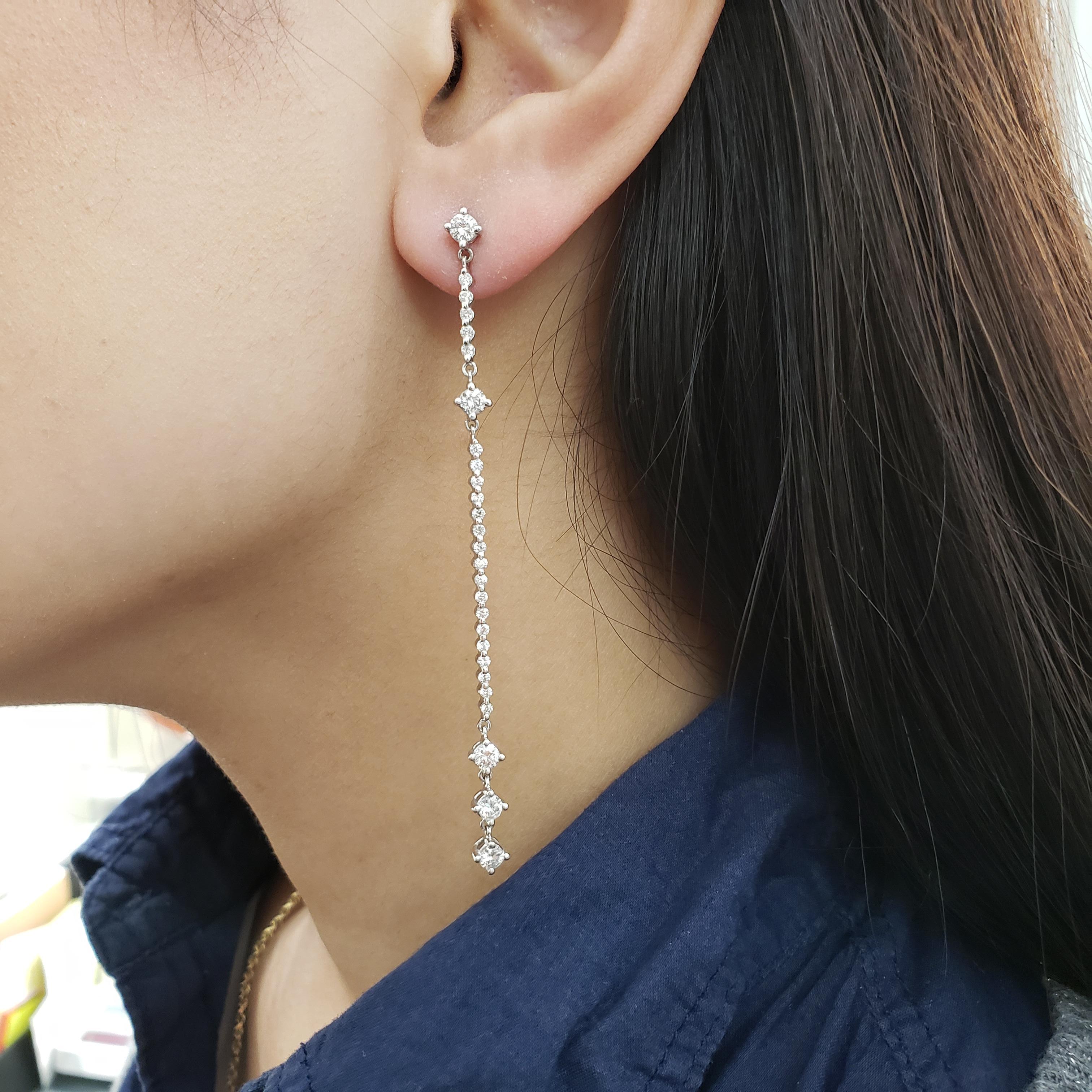 This fashionable pair of drop earrings showcasing a row of round brilliant diamonds set in four brings, elegantly suspended on a row of melee diamonds. Diamonds weigh 1.85 carats total. Made in 18K white gold. 3.25 inches in length.

Roman Malakov