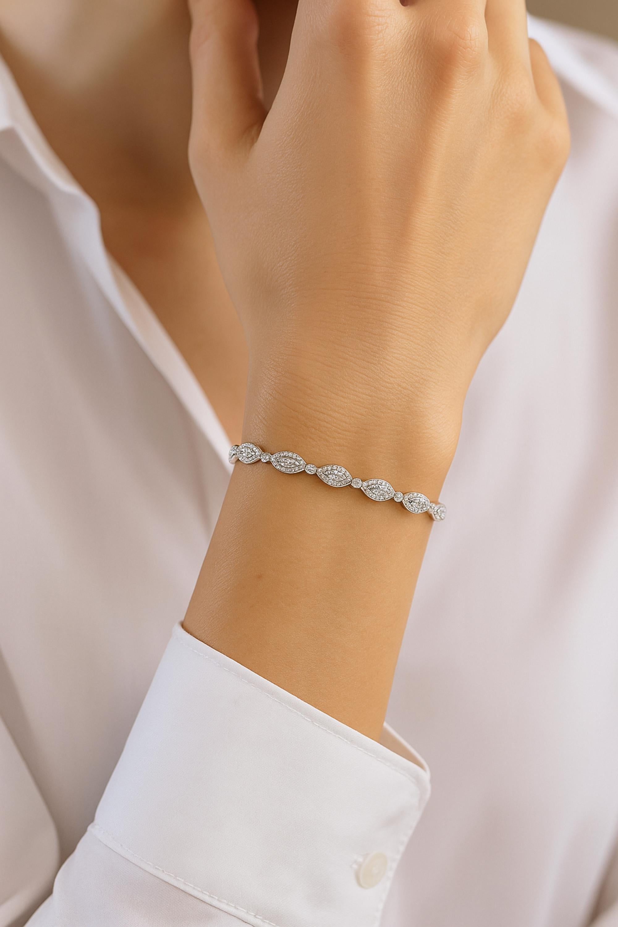 Questo bracciale tennis in oro bianco 14 carati da 1,85 carati SI/H con diamanti a forma di marchesa è caratterizzato da diamanti rotondi incastonati in un gruppo a forma di marchesa che si collegano l'un l'altro formando un braccialetto lineare.
I