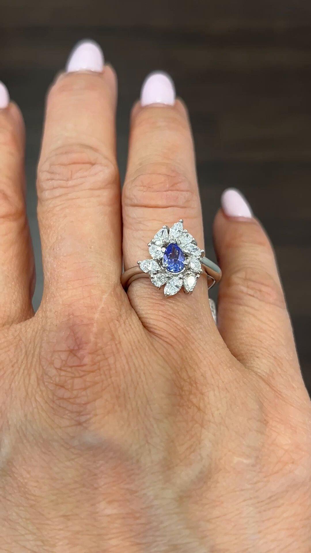 This exquisite ring features a stunning pear-shaped tanzanite stone complemented by sparkling diamonds. Set in platinum, this ring exudes luxury and elegance. The vibrant blue color of the tanzanite and diamonds brings a touch of sophistication to