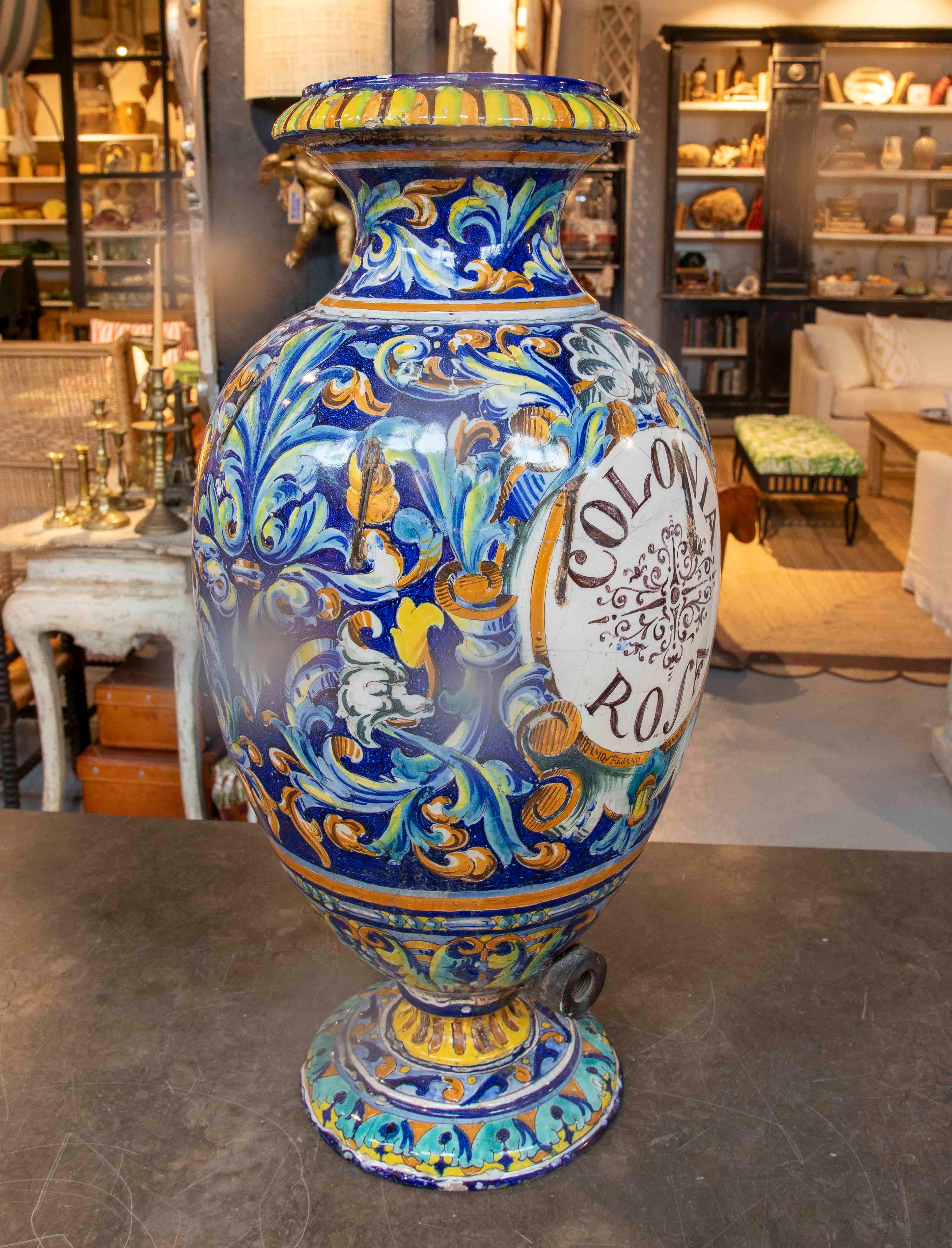 Impressionnant albarelo de Triana, ou grand flacon pharmaceutique, décoré de motifs céramiques et végétaux brillamment émaillés, typiques de la Renaissance italienne. Cette pièce, probablement utilisée dans d'anciennes apothicaireries ou