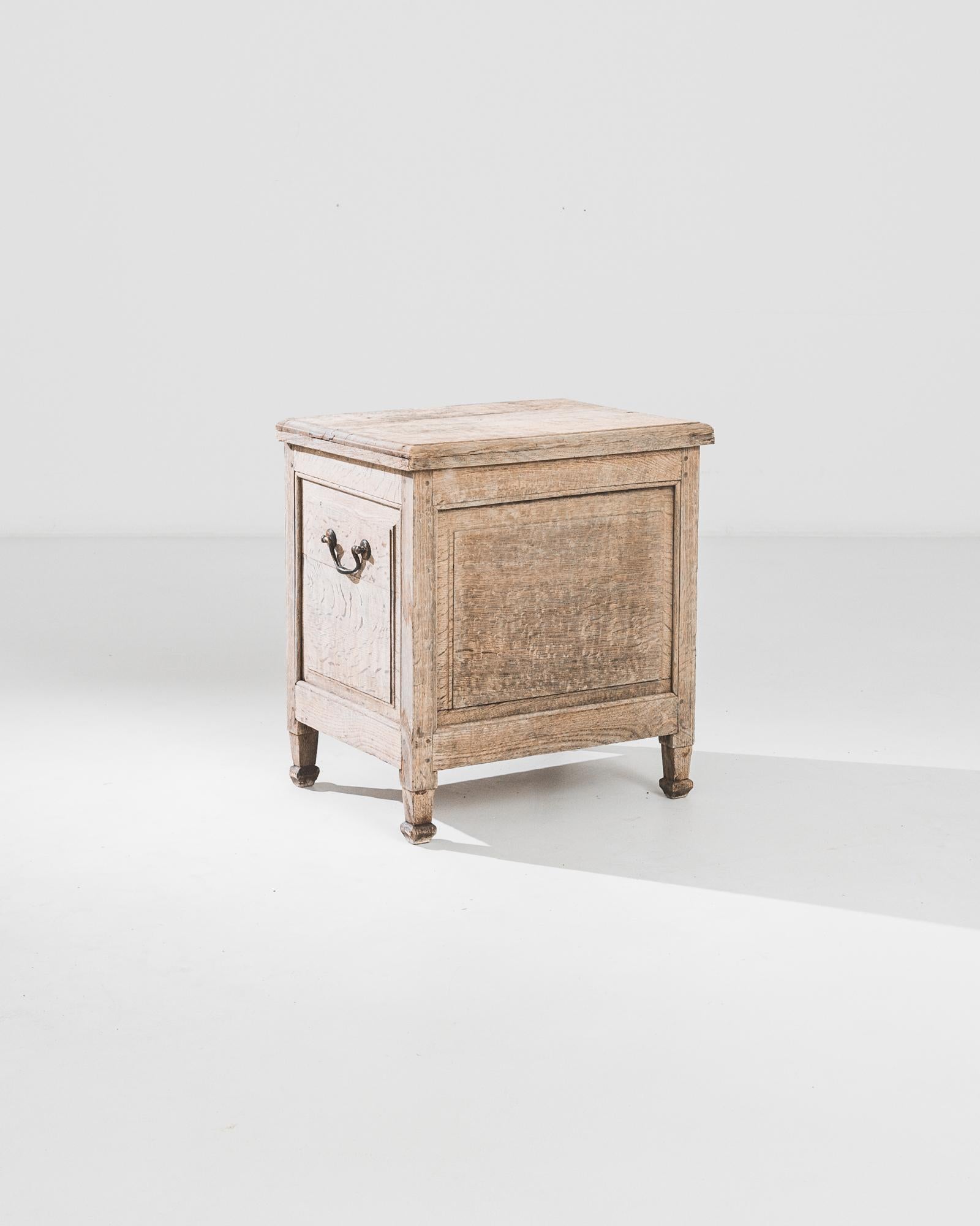 This bleached oak coffer was produced in Belgium, circa 1850. A handsome antique coffer on four tapered feet, featuring a flip-top lid and cast iron handles allowing for easy transportation. The pale sand tone and smoky grain of the natural oak take