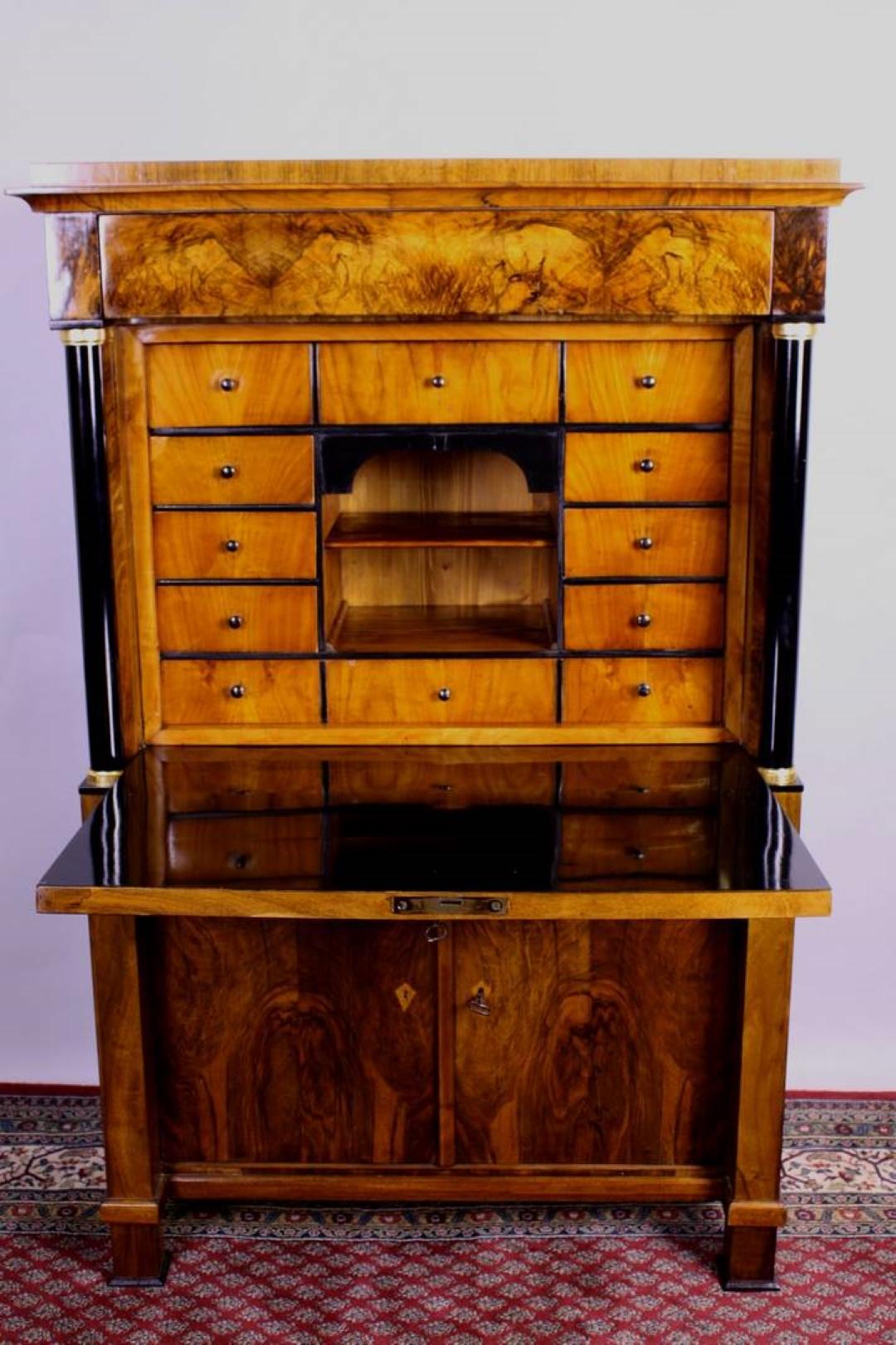 Original antique Biedermeier secretaire or bureau with beautifully ebonized framing columns. This unique single piece from the 1860s convinces with its amazing red-brown cherrywood veneer and the hand-polished shellac finish. In a restored, perfect