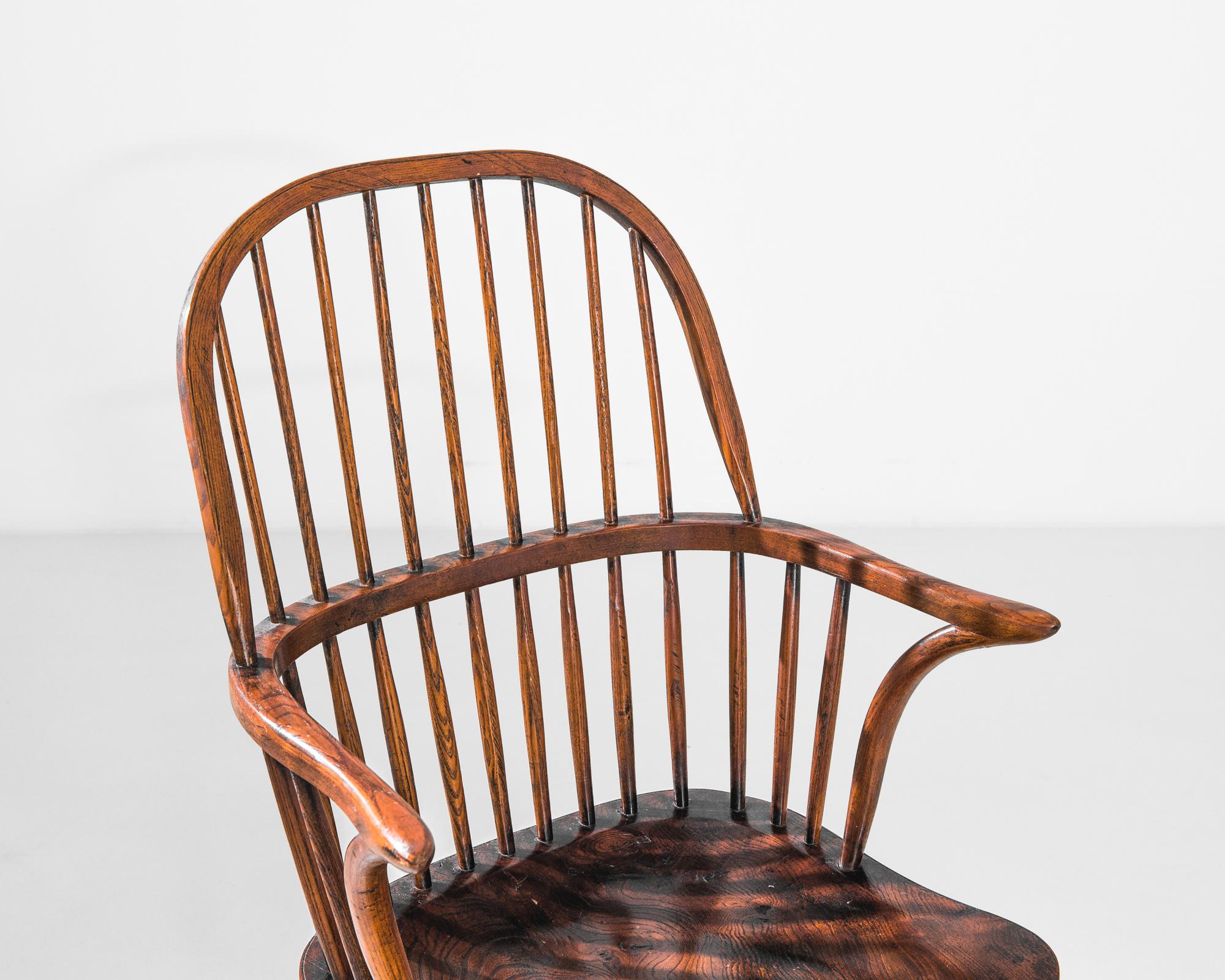 A wooden armchair from 1850s Britain. The windsor chair design lifts elements from traditional farmhouse chairs — the turned legs, contoured seat and spindled backrest — and recombines them into a visually striking yet homey form. The arch of the