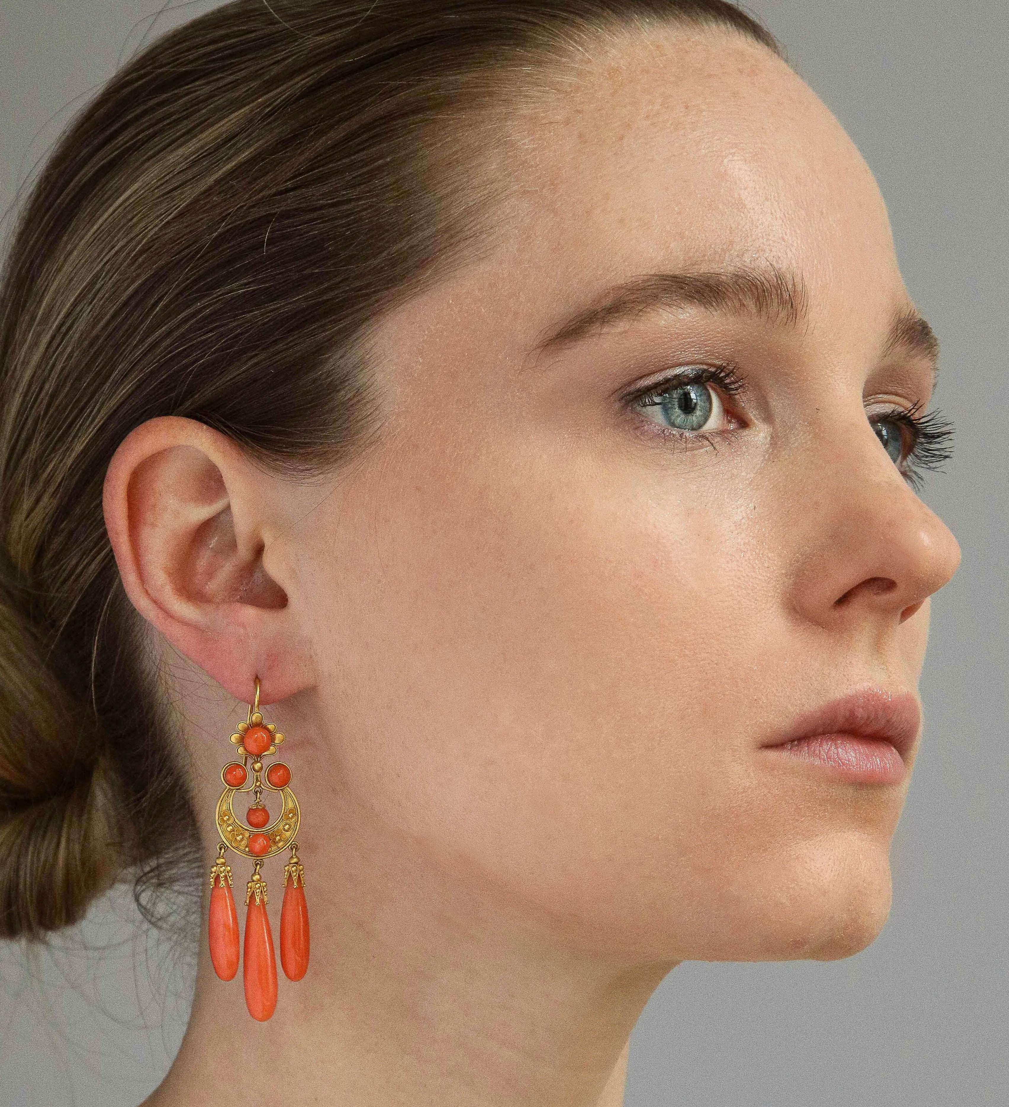 A beautifully hand crafted Victorian pendant/brooch and earring suite in Etruscan style, made of 18K yellow gold and natural Mediterranean coral. Maintained in original state in its fitted case. Pendant 1 1/2 inches x 3 3/4 inches; and earrings 3/4