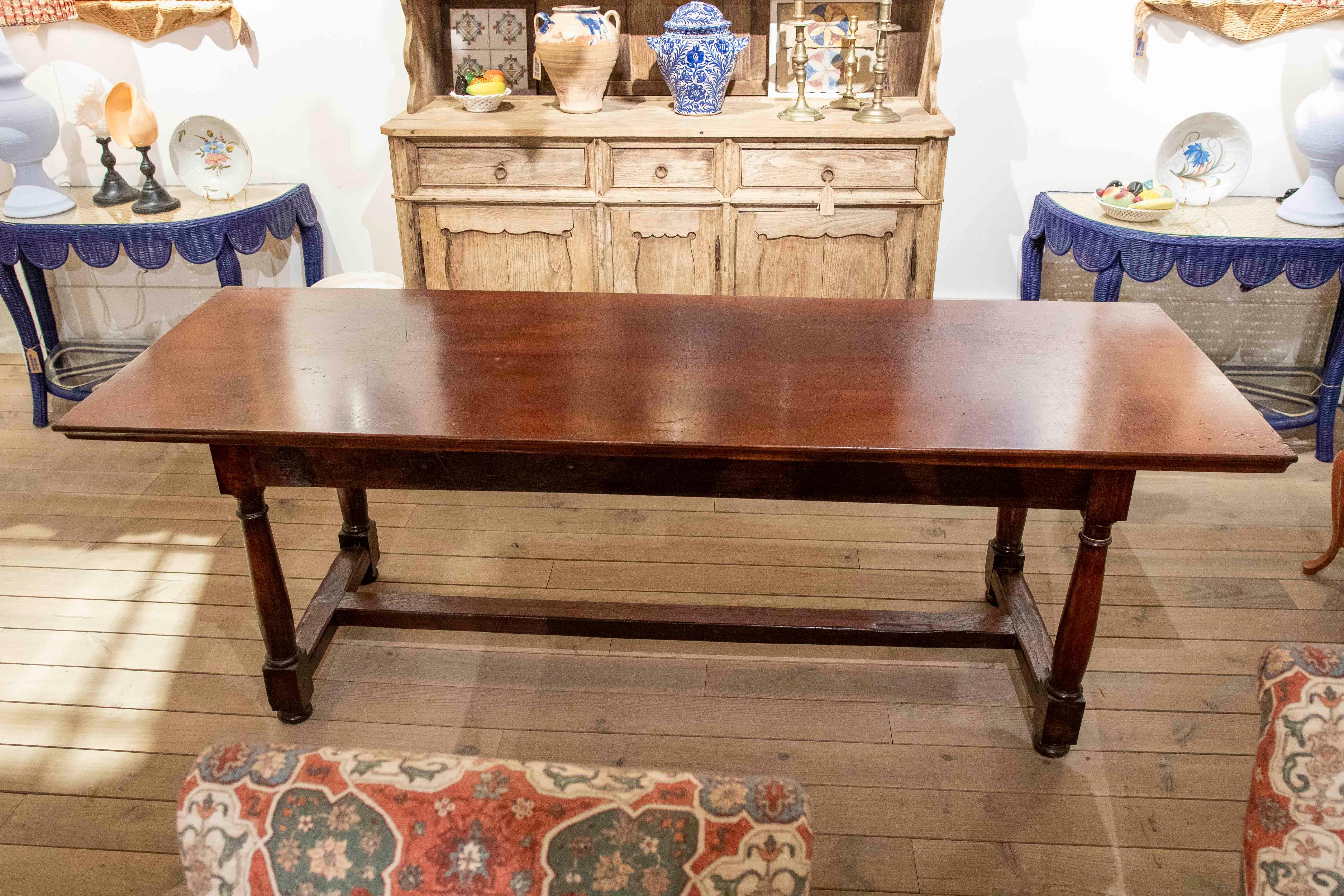 Elegant and functional, this rectangular dining table is crafted from solid wood with a warm, satin finish that highlights the natural beauty of the grain. Its understated and balanced design stands out thanks to the robustness of its turned legs,