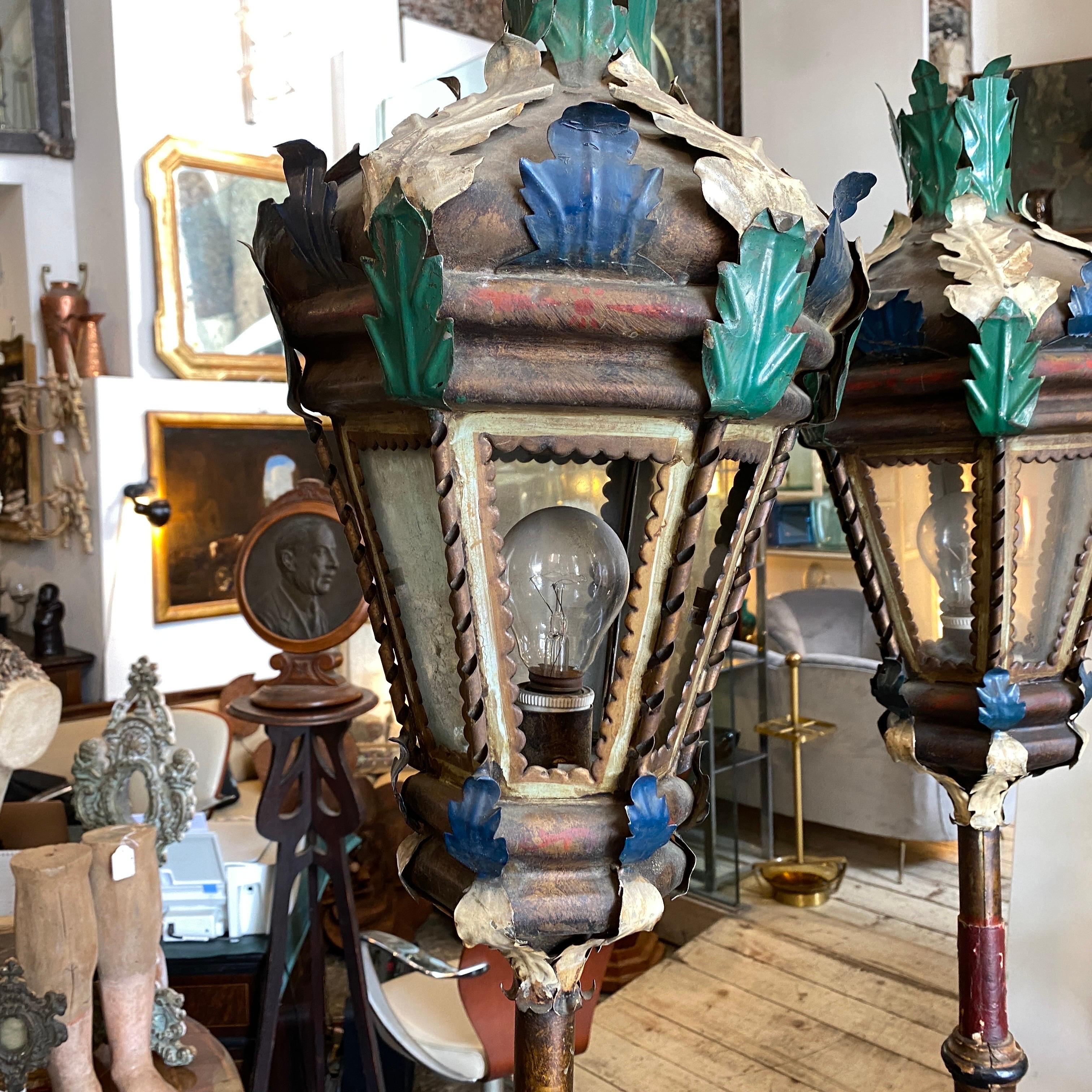 Deux lampadaires de parade religieuse en bois et fer peint transformés et électrifiés au début des années 1900 en lampadaires. Conditions originales, signes d'utilisation et d'âge, deux verres manquants, ils peuvent être utilisés à la fois 110-240