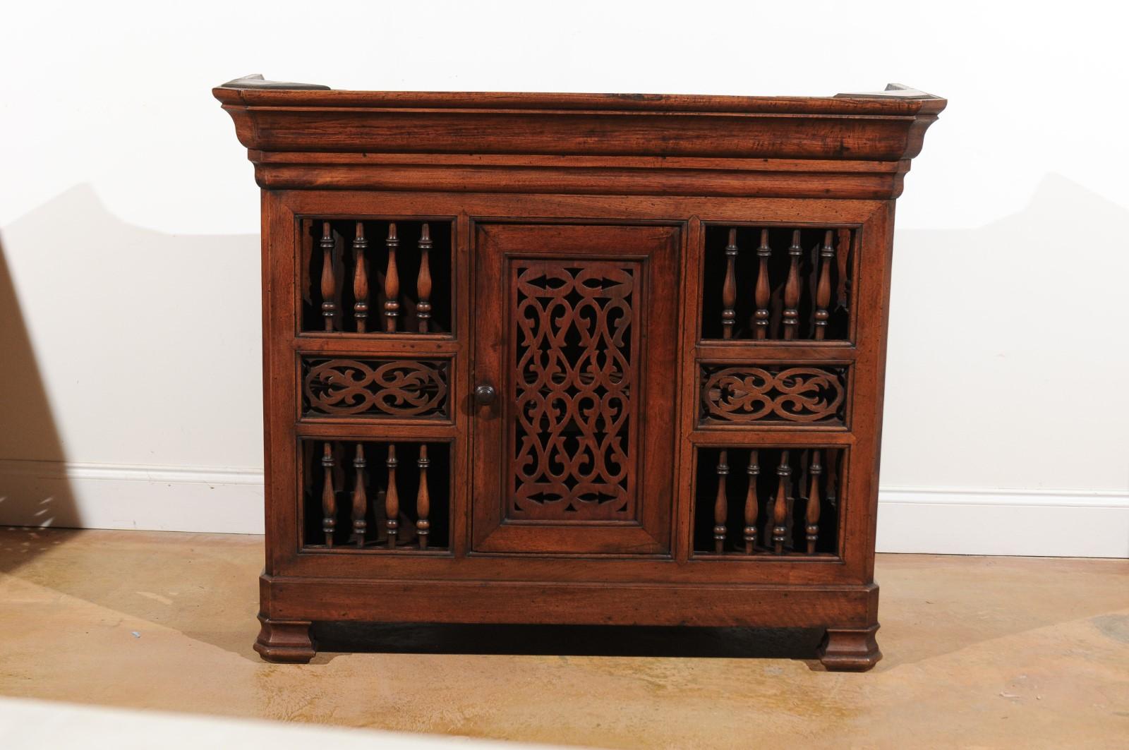 A French Louis-Philippe period walnut bread box from the mid-19th century with central door, spindle-shaped motifs and openwork. Born in the French southeastern Dauphiné area at the end of the reign of King Louis Philippe, this walnut panetière