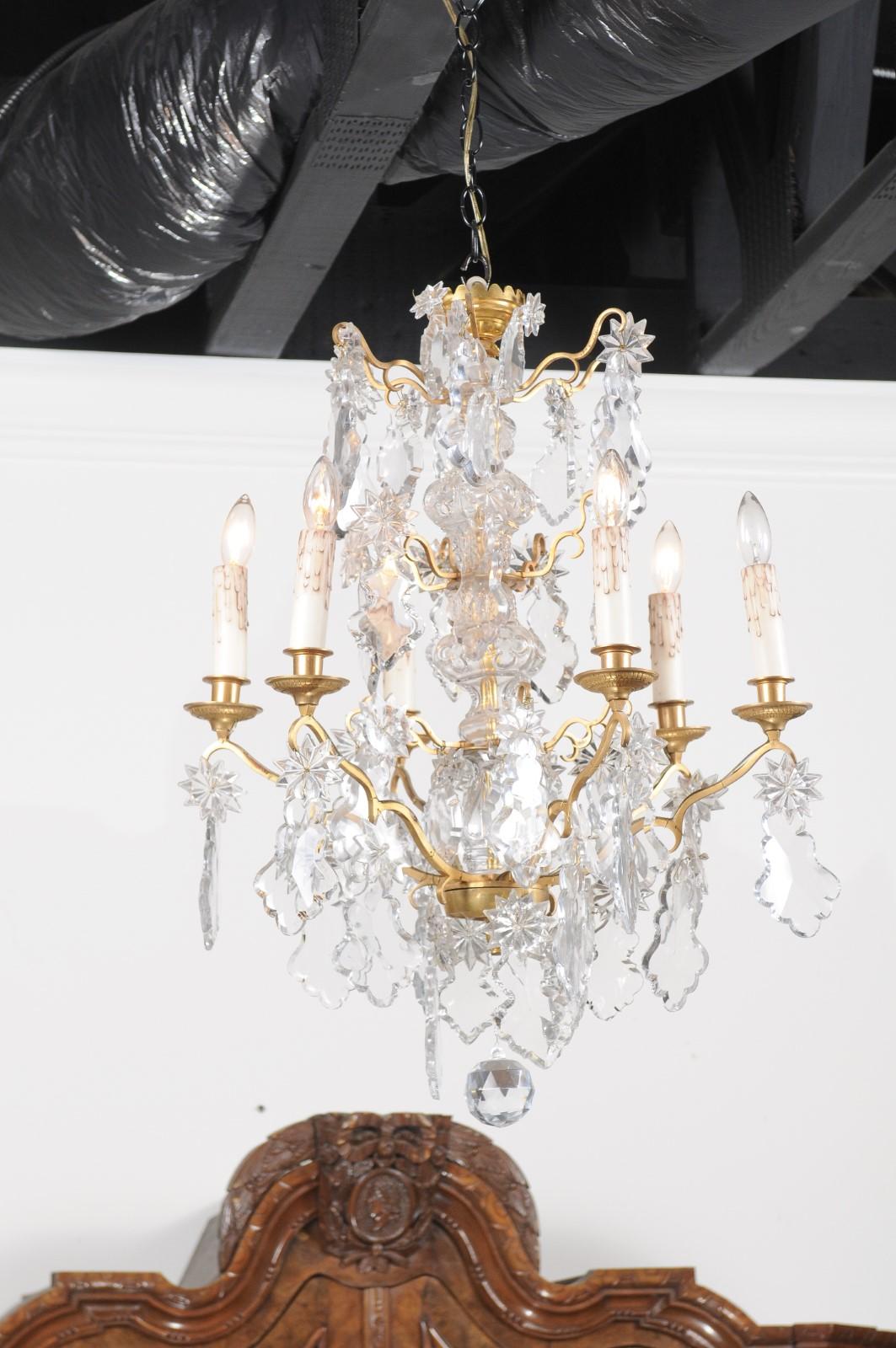 A French Napoleon III period six-light crystal chandelier from the mid-19th century, with brass armature, pendeloques and rosettes. Born in France at the beginning of Emperor Napoleon III's reign, this six-light chandelier features a central crystal