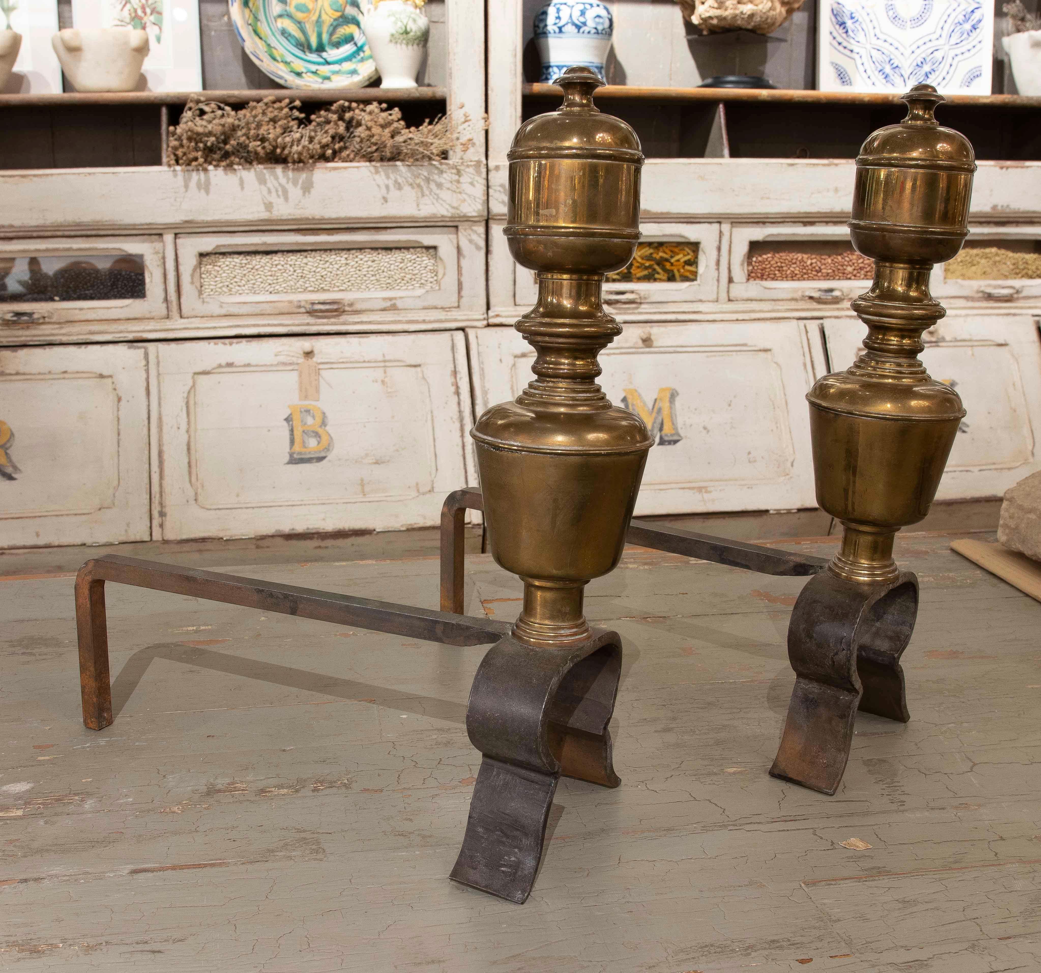 Set of two fireplace surrounds made with wrought iron bases and top details in bronze. Its sober and elegant design combines resistant materials with a classic aesthetic, ideal to complement the functionality and style of a traditional fireplace.