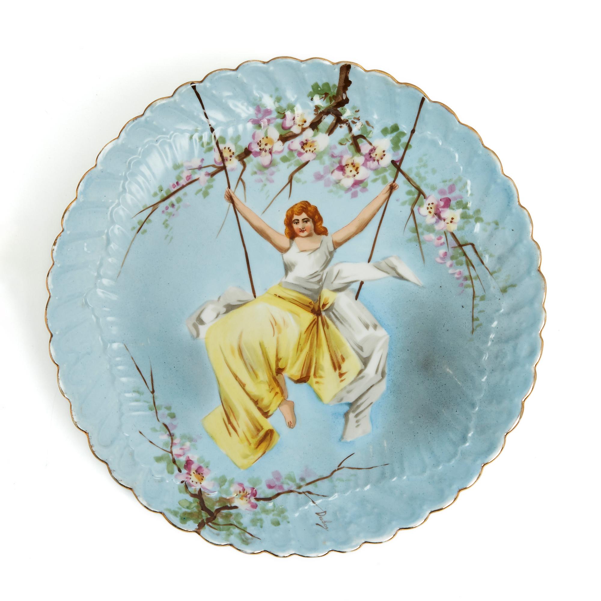 Set composed of 2 dishes illustrated by Paul Duboy (1830-1886) who was a sculptor then ceramist, with the motif of 2 women on a swing surrounded by flowering branches. Diameter 34 cm, height 4.2 cm. The 2 dishes are very vintage and the pattern
