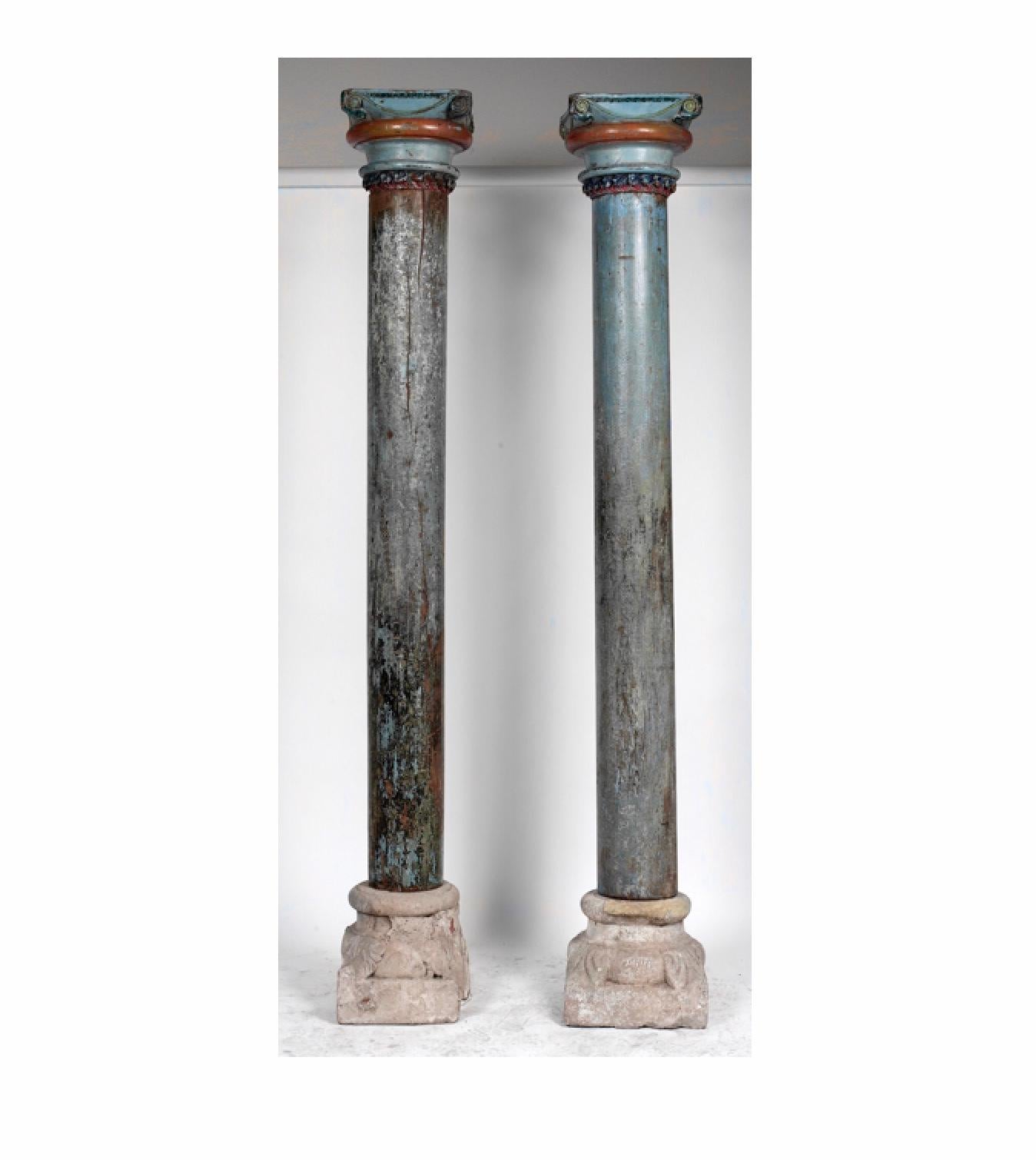 1850s French blue painted carved wooden columns with decorative carved stone bases. A unique pair of statement-making architectural accents, the aged aquamarine paint with crimson, blue and green detailing gives these columns an old-world, romantic