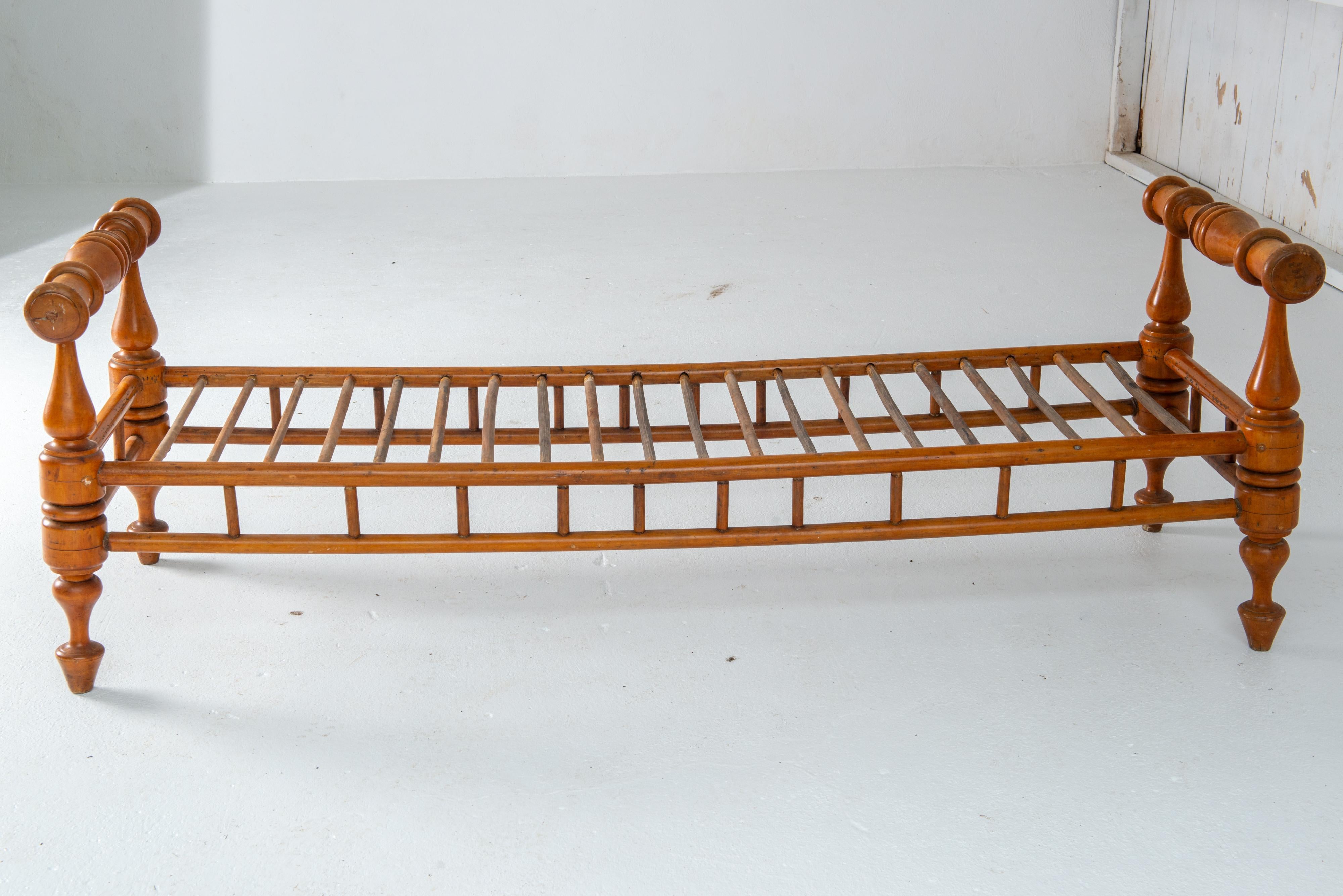 This is a very sculptural daybed, long and lean with very dynamic artistic end pieces. It is solid maple crafted in the 1850s. With fine cushion this is an outstanding addition to any room- modern or traditional. Sturdy and ready to go.