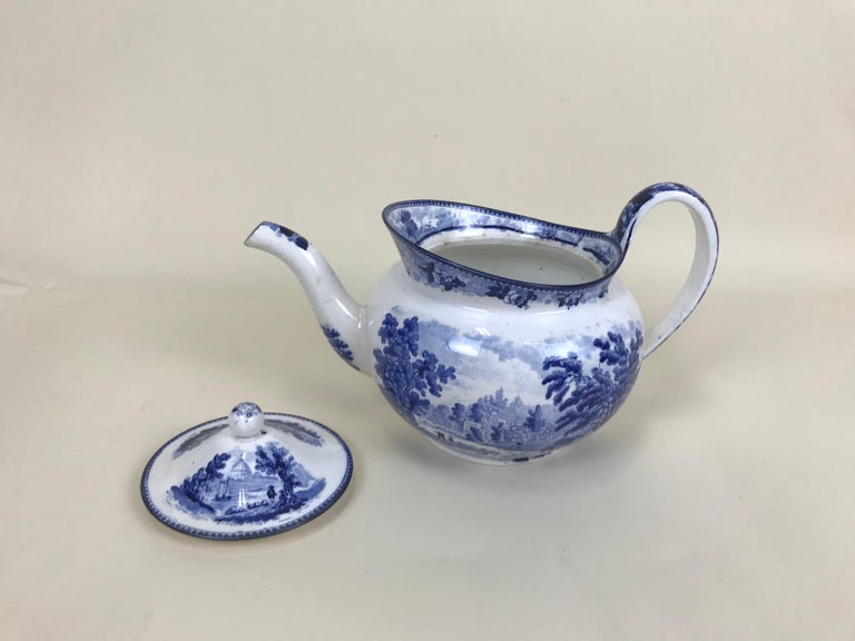 Large English Victorian blue and white transfer printed earthenware teapot made in Staffordshire.

In excellent condition with no chips, cracks or other damages, the teapot is boat shaped and decorated on both sides and lid with a pastoral scene