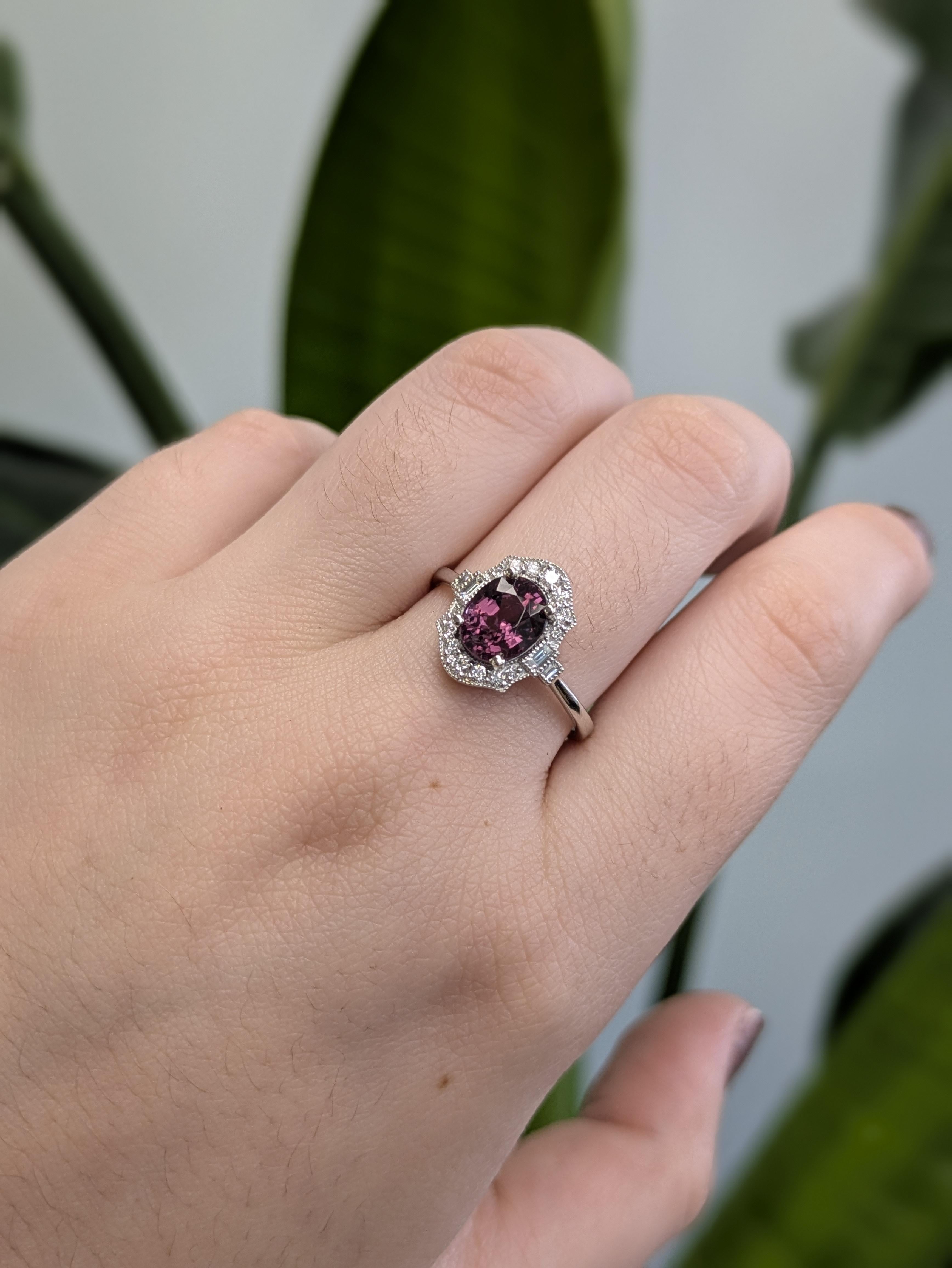 Dieser 1,85 Karat schwere lilafarbene Spinellring mit Vintage-Flair zeichnet sich durch einen strahlenden ovalen Edelstein aus, der von einem Kranz funkelnder natürlicher Diamanten eingerahmt wird. Der aus massivem 14-karätigem Weißgold gefertigte