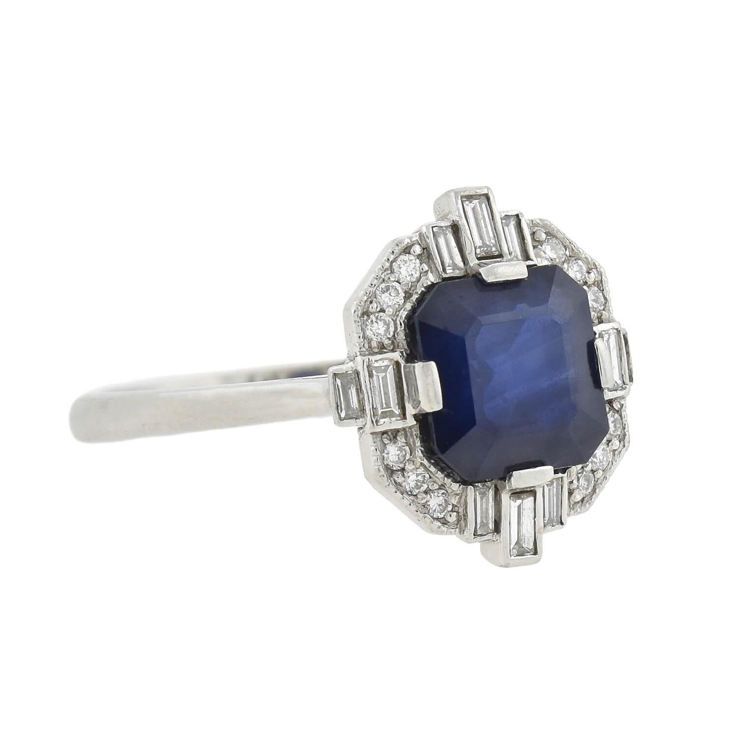 A beautiful contemporary ring inspired by the Art Deco era! Crafted in platinum, this stunning piece features a natural Asscher Cut blue sapphire which rests in an Art Deco style halo setting. The deep, rich sapphire has an exact weight of 2.01