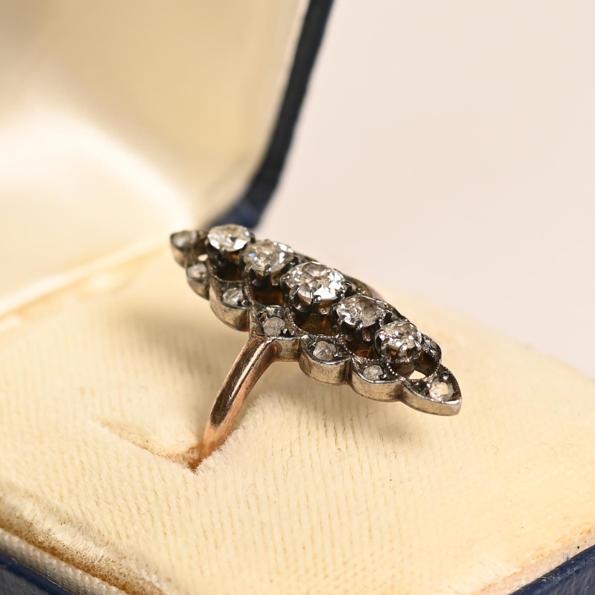 Dieser exquisite, antike Navette-Ring ist eine atemberaubende Mischung aus Silber und 14-karätigem Gelbgold und zeigt zeitlose Handwerkskunst aus der viktorianischen Ära. In der Mitte befindet sich eine anmutige Reihe von fünf Diamanten im alten