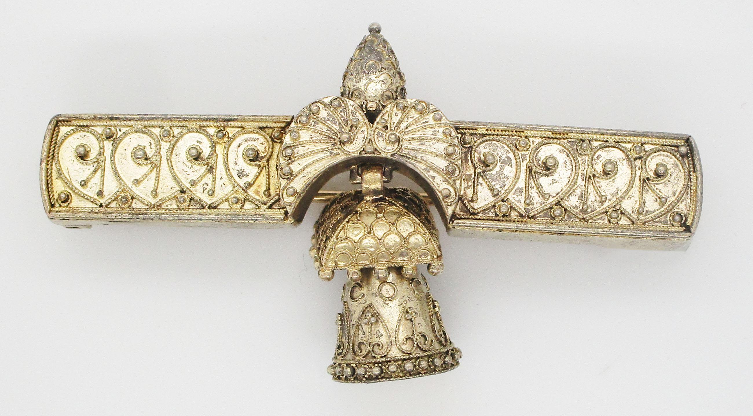 This remarkable Victorian Etruscan bar pin is in 14k yellow gold and has a stunning articulated bell dangle at its center! The bar pin has an incredible amount of fine detailing in subtle scrolling and a winged symbol overlay. The elegance and