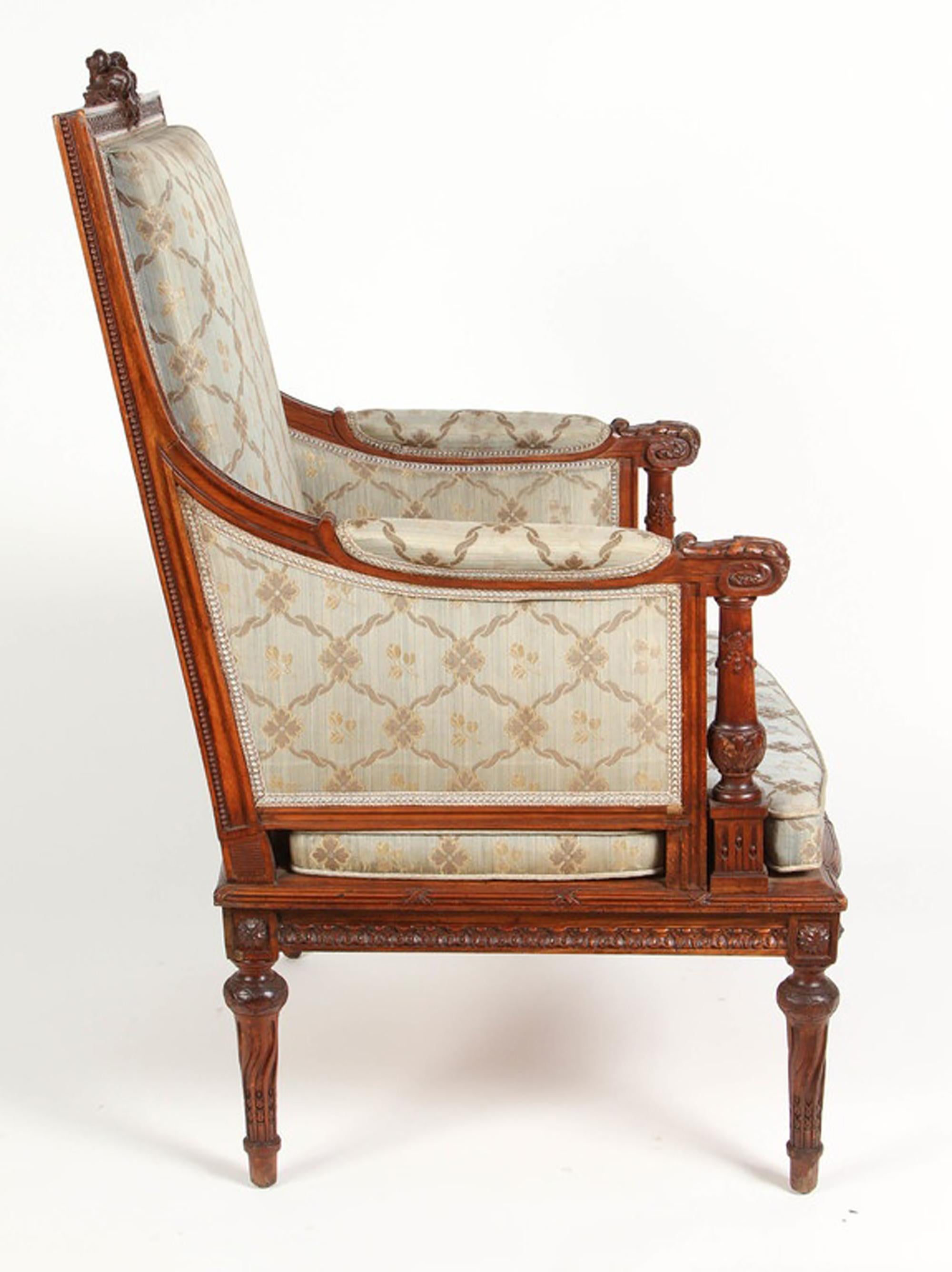 Ein kunstvoll geschnitzter Louis-XVI-Armlehnstuhl aus Nussbaum von 1860 aus Frankreich. Der Stuhl hat seine Originalpolsterung, die ein Muster aus großen und kleinen ineinandergreifenden Rauten aufweist. Die Schnitzereien sind in ausgezeichnetem