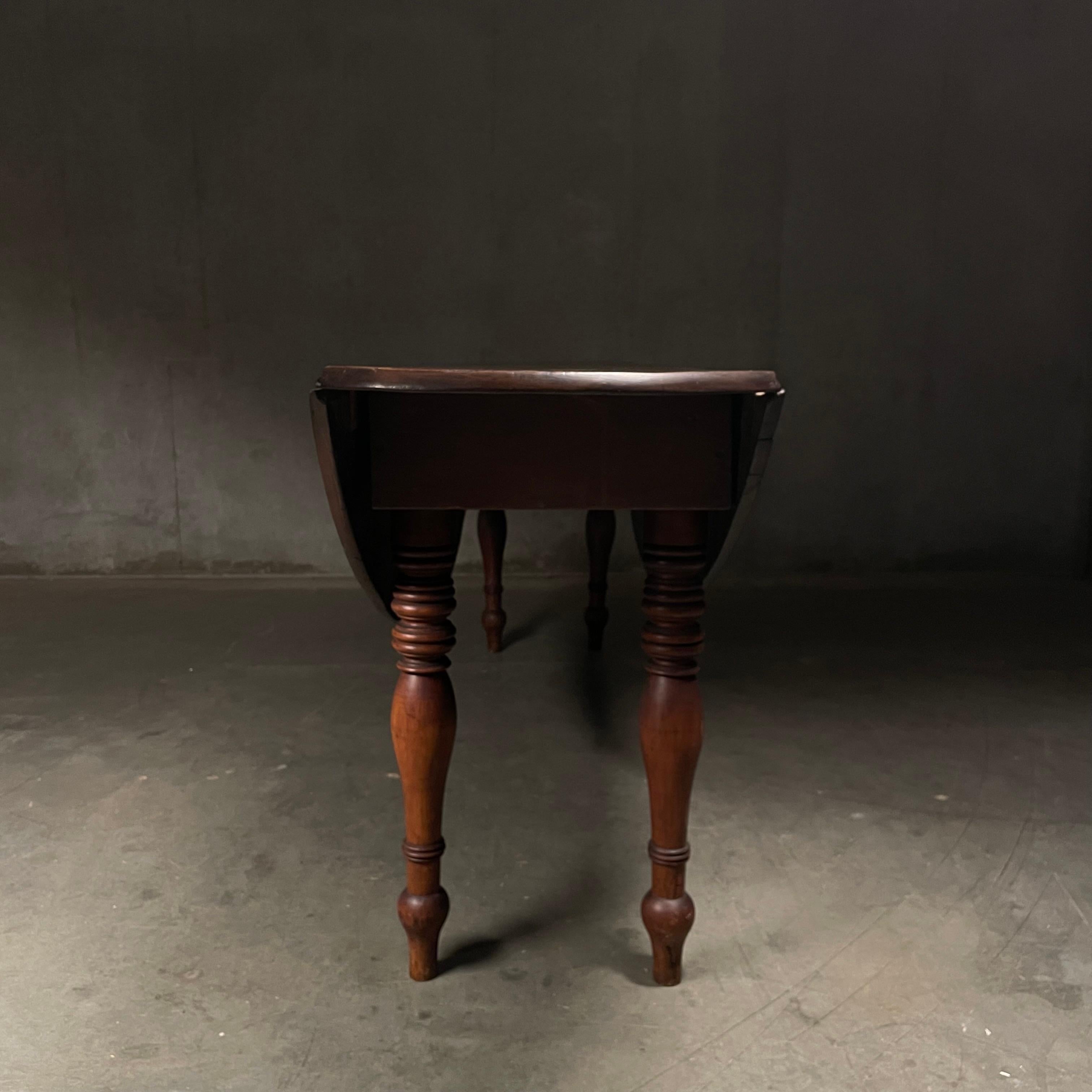 A very good drop leaf solid mahogany big board constructed table in original patina finish . 
Table was found in the Canadian maritimes.   Once open thus is a 36 inches wide oval dining table.   Its dropped state makes a very nice sofa table. 