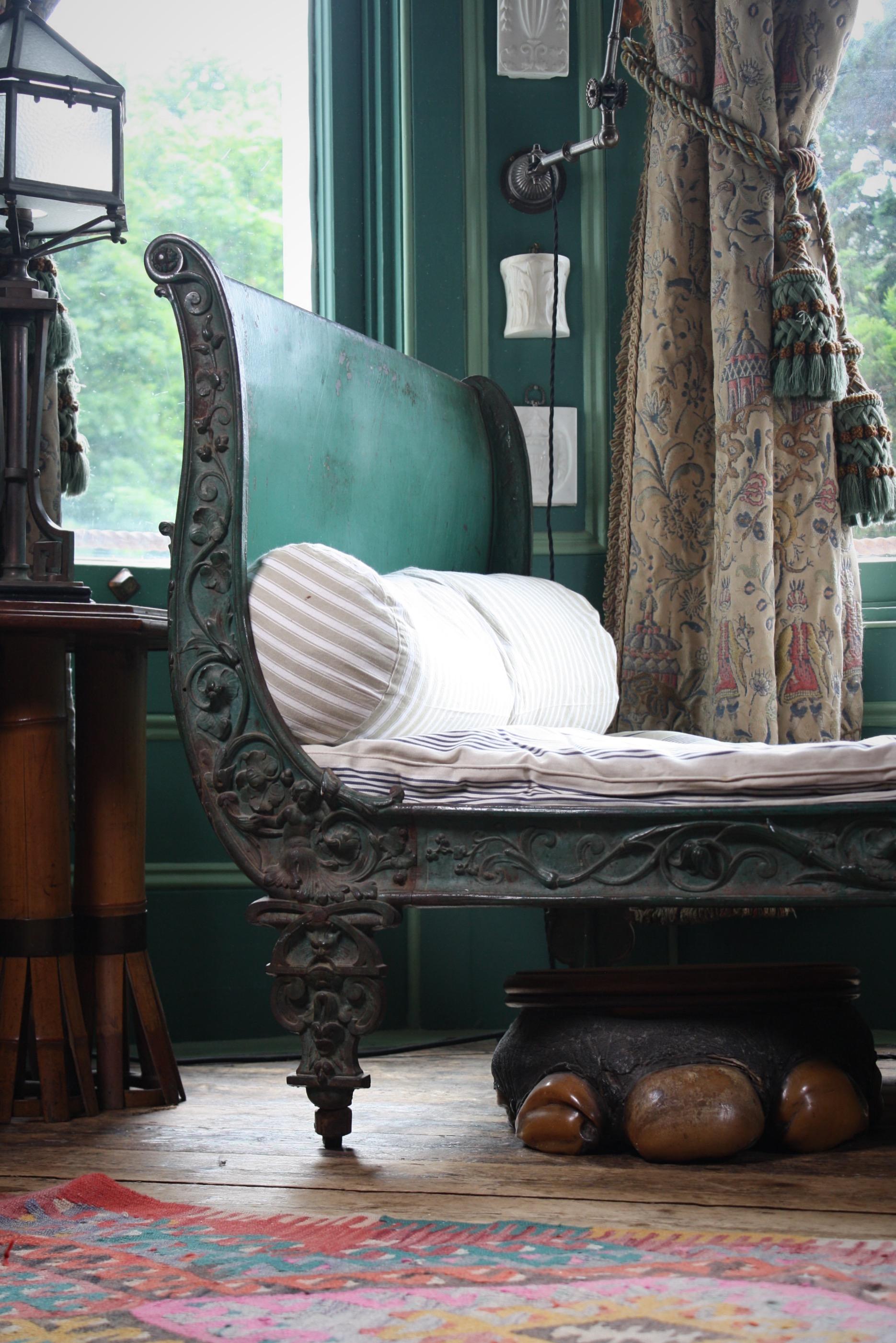 A wonderfully worn circa 1860 Napoleon lll cast iron daybed, features curved sides with intricate floral scroll work figures and faces with a nod to the rococo style 

Original green paint, faded, chipped, scratched consistent with age and truly