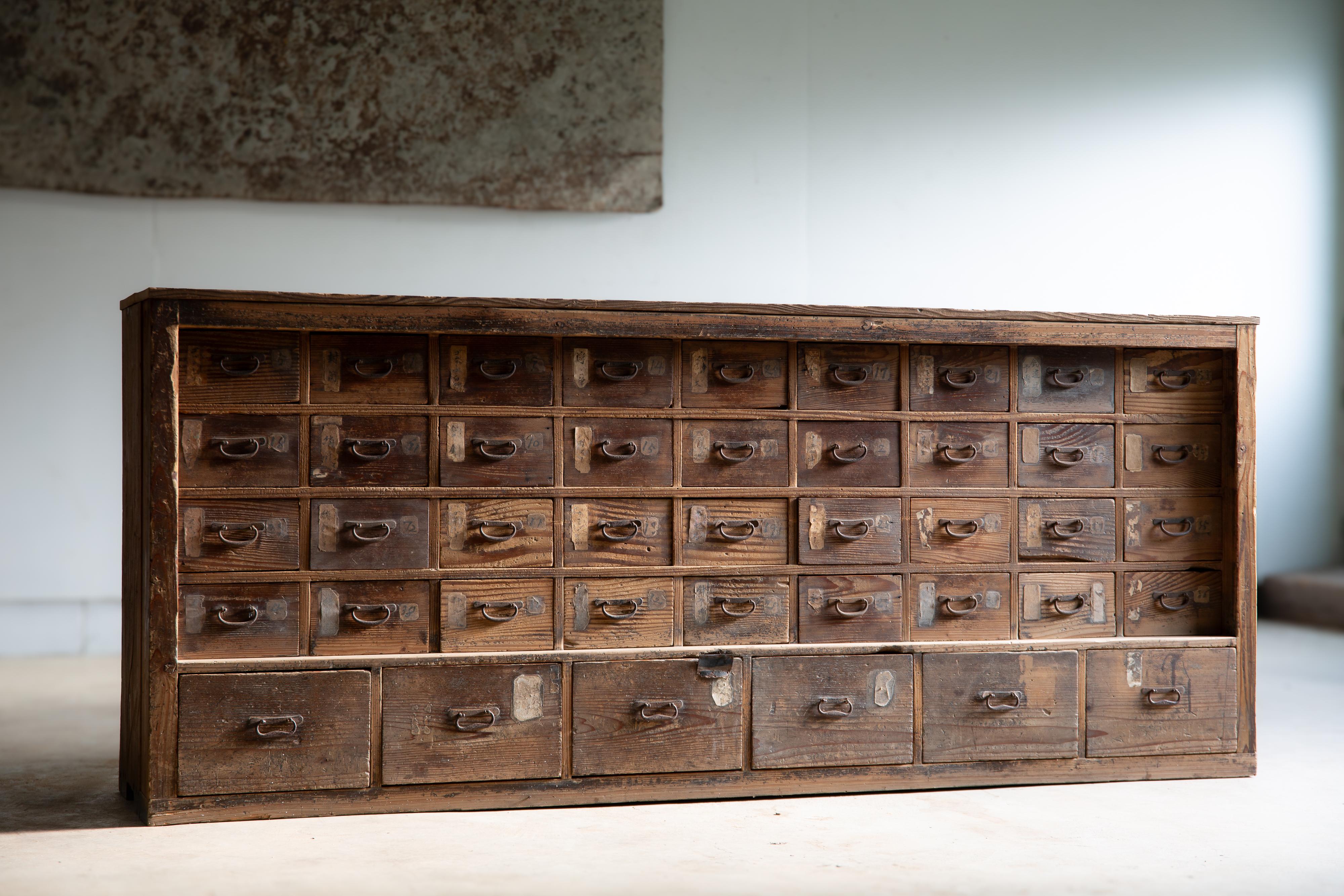 Dieser große Ladenschrank, tansu Kommode, ist in der Ader von Kusuri dansu (Medizin / Apotheker Brust).
Produkt der Meiji-Ära (1860-1910), Schätzung nach Stil und Zustand. Es sind noch Reste von alten Papieretiketten vorhanden.
Nach der Aufschrift