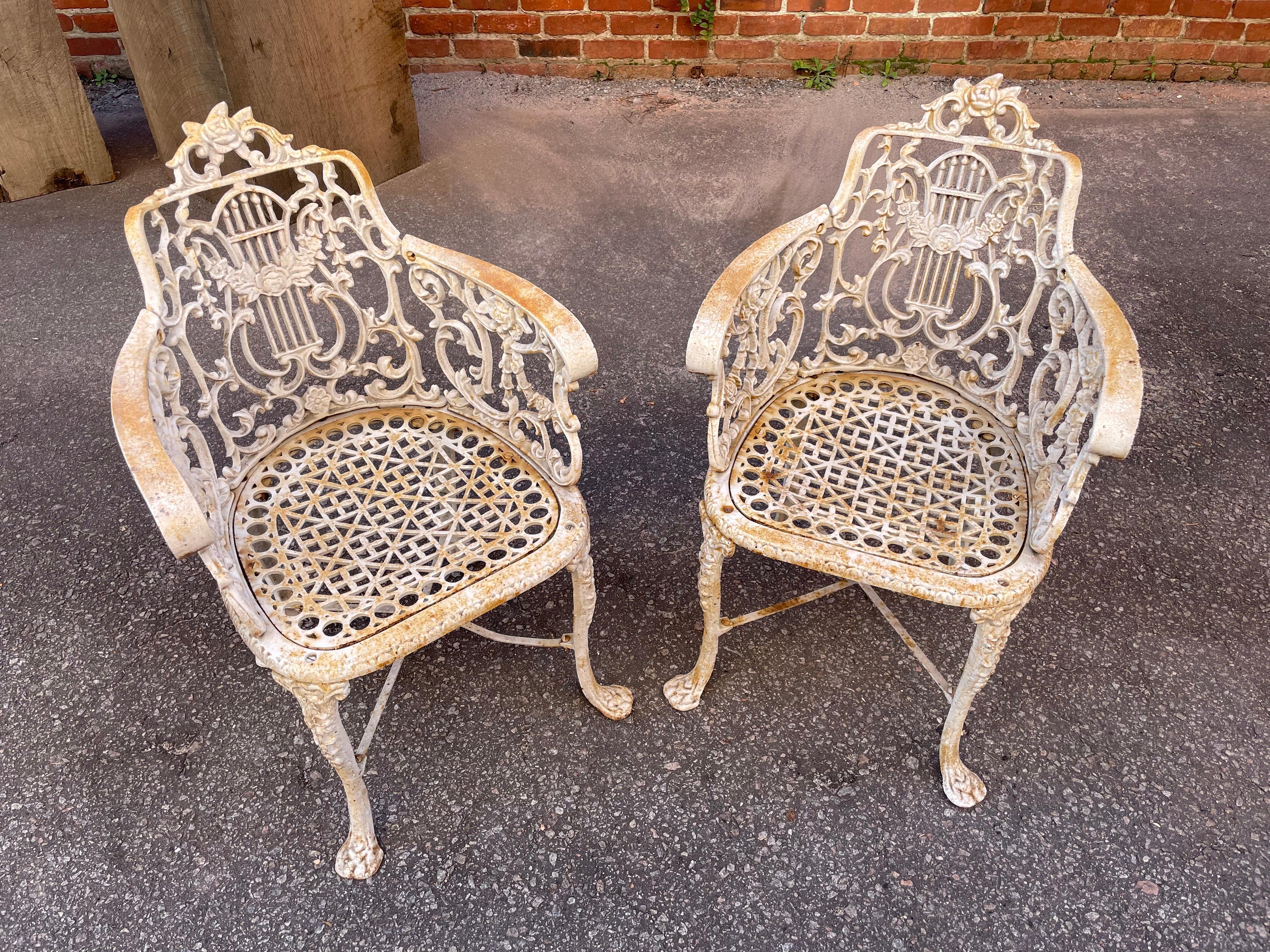 Own an authentic pair of antique Neoclassical style garden armchairs attributed to the Robert Wood Foundry. Original white painted finish on cast iron. Philadelphia, c. 1860s.