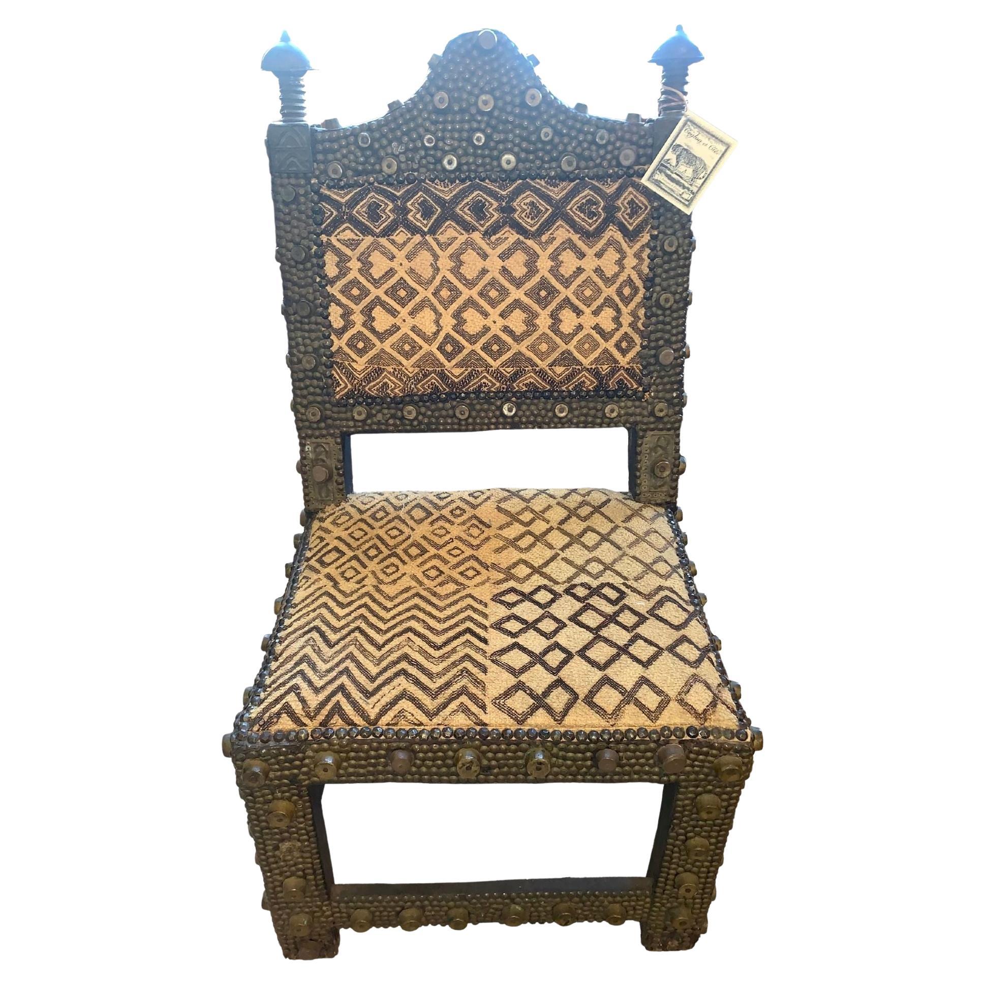 chaise du roi Ashanti des années 1860
Ferronnerie avec rails et goujons de métier 
Épis de faîtage en bronze
Tissu Kuba.
