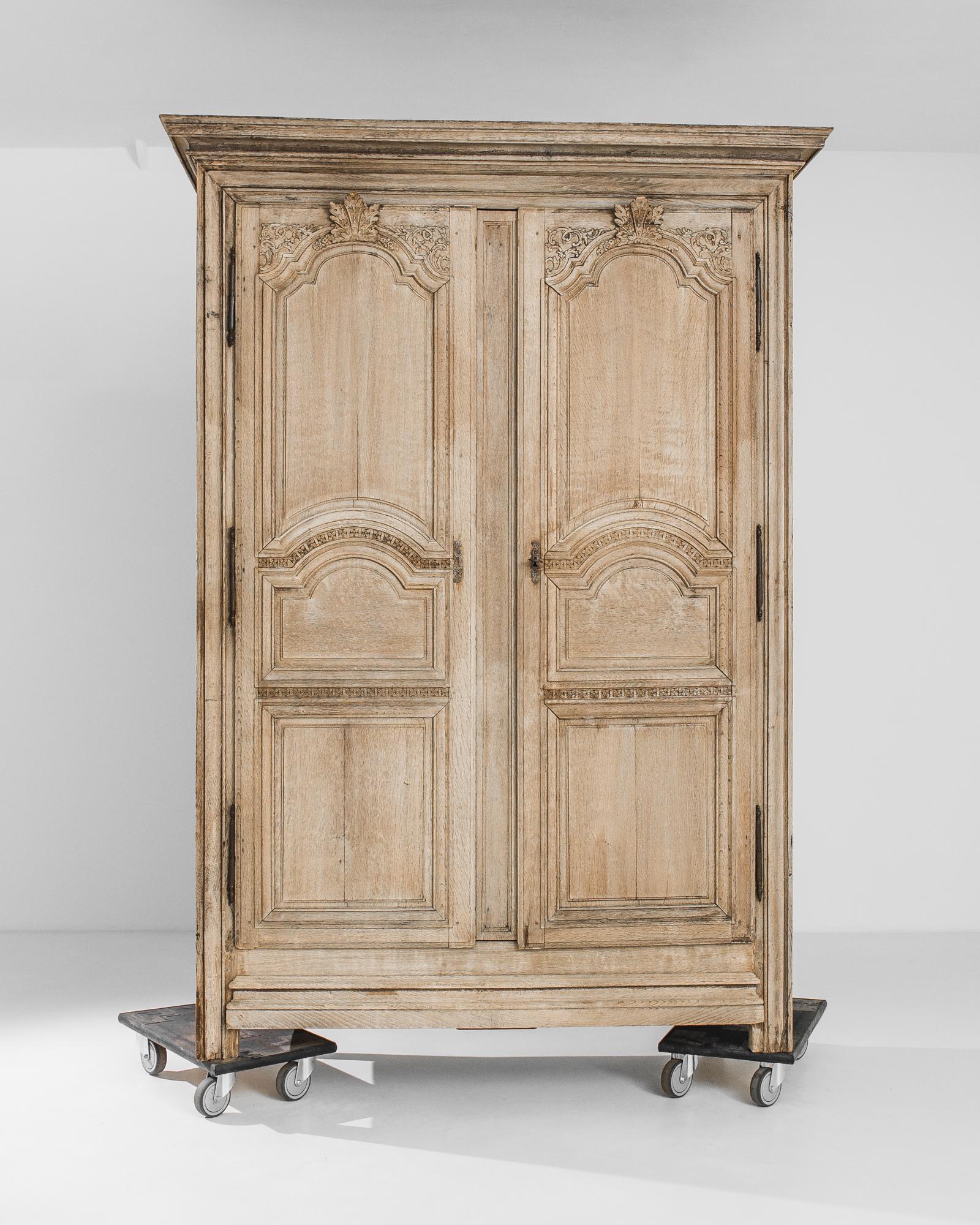 Intricate carved detail lends this oak armoire from 1860s France a verdant air. The graceful arches of the paneled doors are crowned by carved fleur de lis, winding acanthus leaves and delicate forget-me-not flowers. A pattern of carved four-petaled