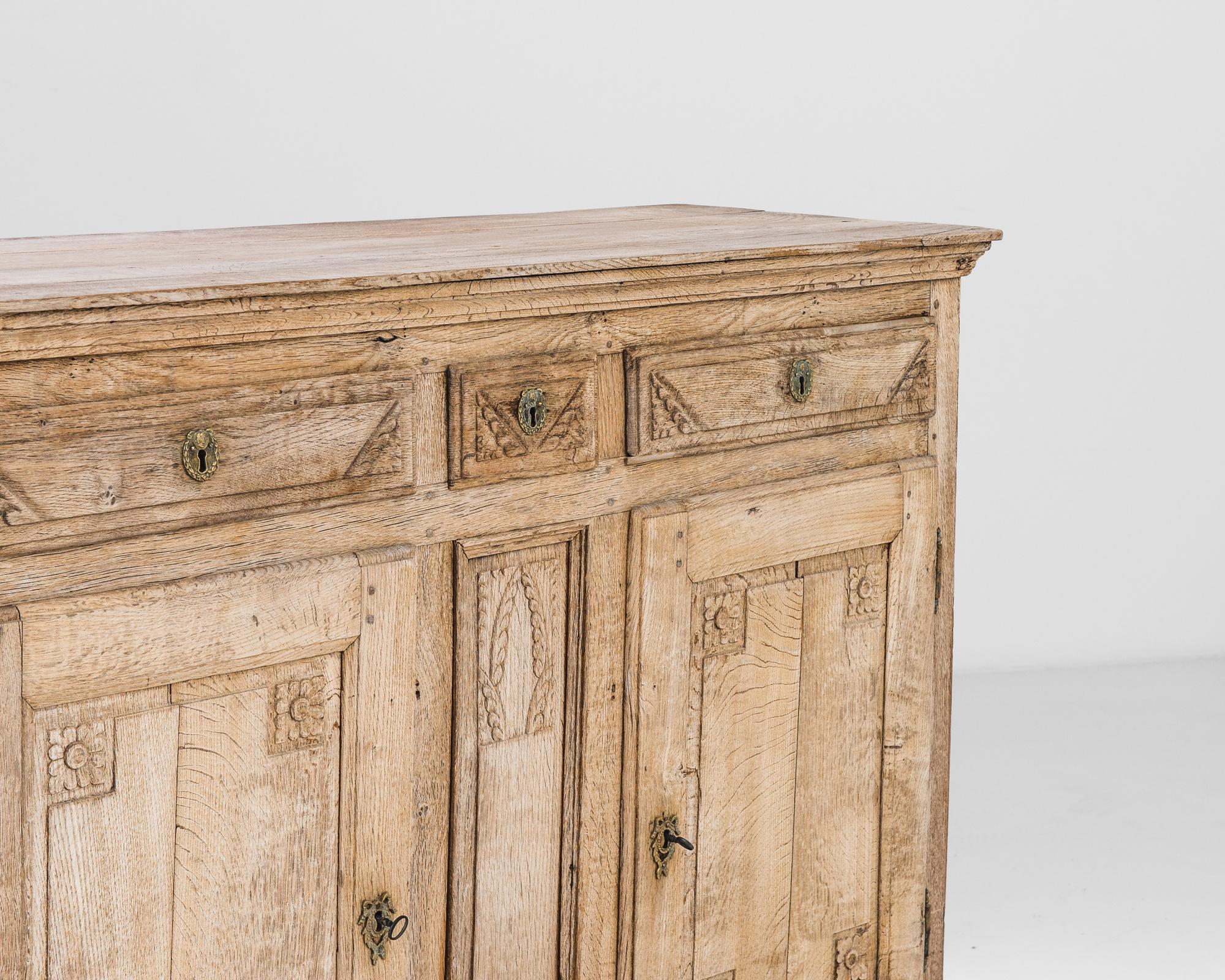 Carved detail enlivens this antique oak buffet. Made in France in the 1860s, motifs of leafy rosettes and victory palms give a verdant, triumphant impression. The wood has been restored in our workshops to a natural finish, revealing the warm russet