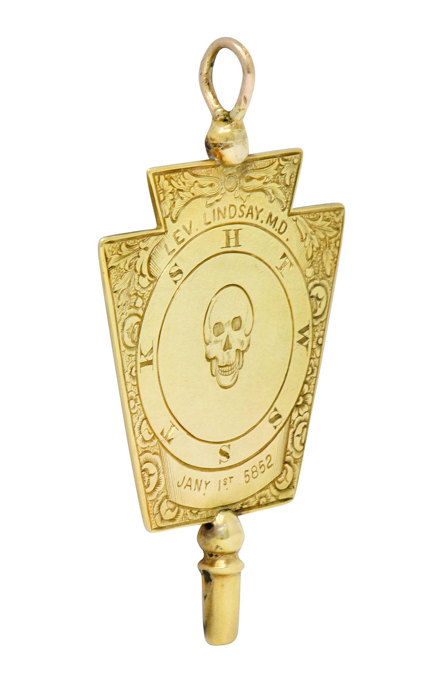 Pendant is a Freemason watch key shaped as a keystone for a Mark Master Lodge ranking

Deeply engraved with a skull, arch, eye, and other Freemasonic motifs

With an ornate floral engraved border

Tested as 14 karat gold

Circa: 1860s

Measures: 1