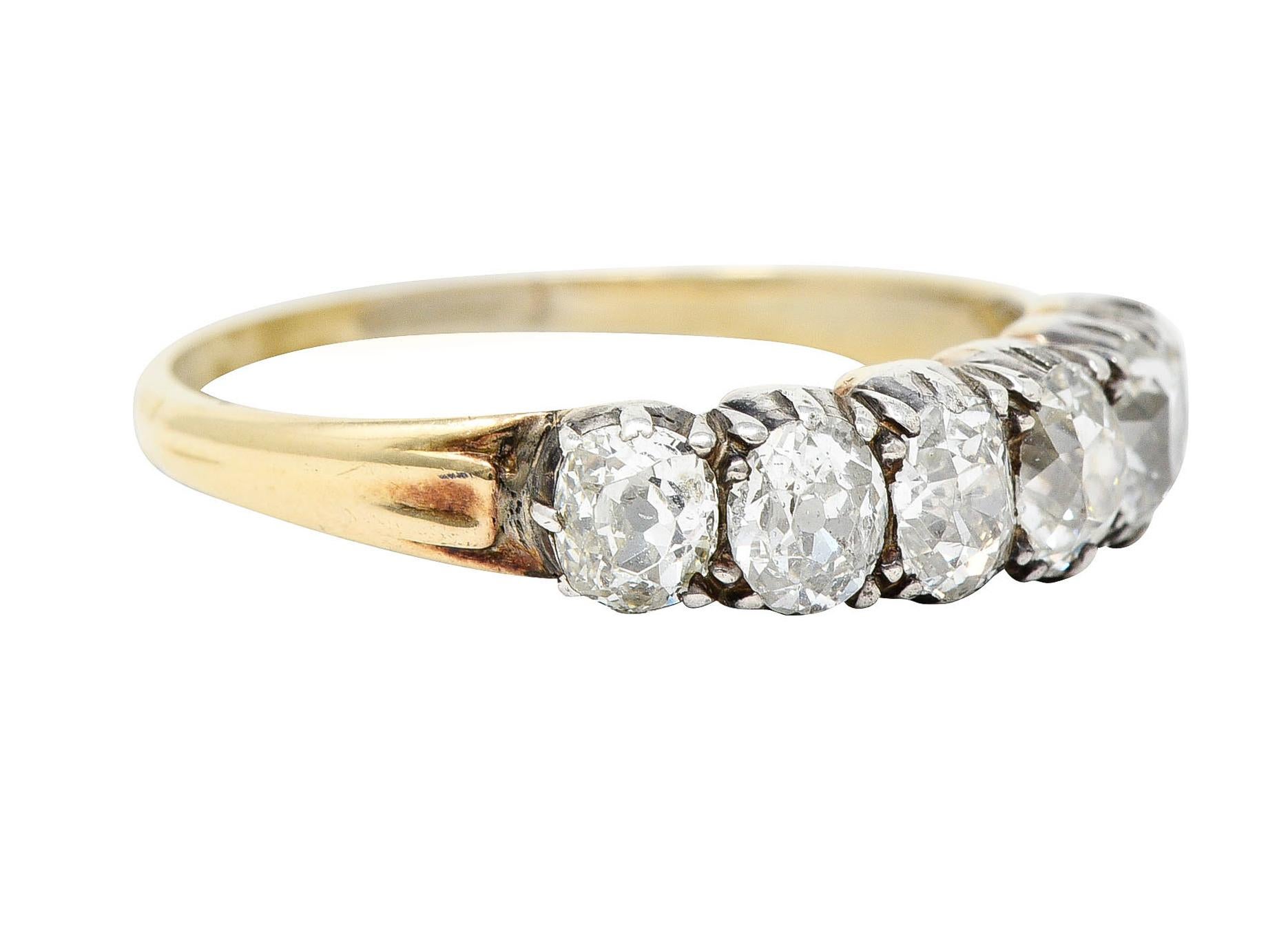 Band ring features old mine cut diamonds weighing in total approximately 1.45 carats - H/I color with SI clarity

Well matched and set in dimensional silver forms

Completed by a yellow gold shank with subtly grooved shoulders

Tested as