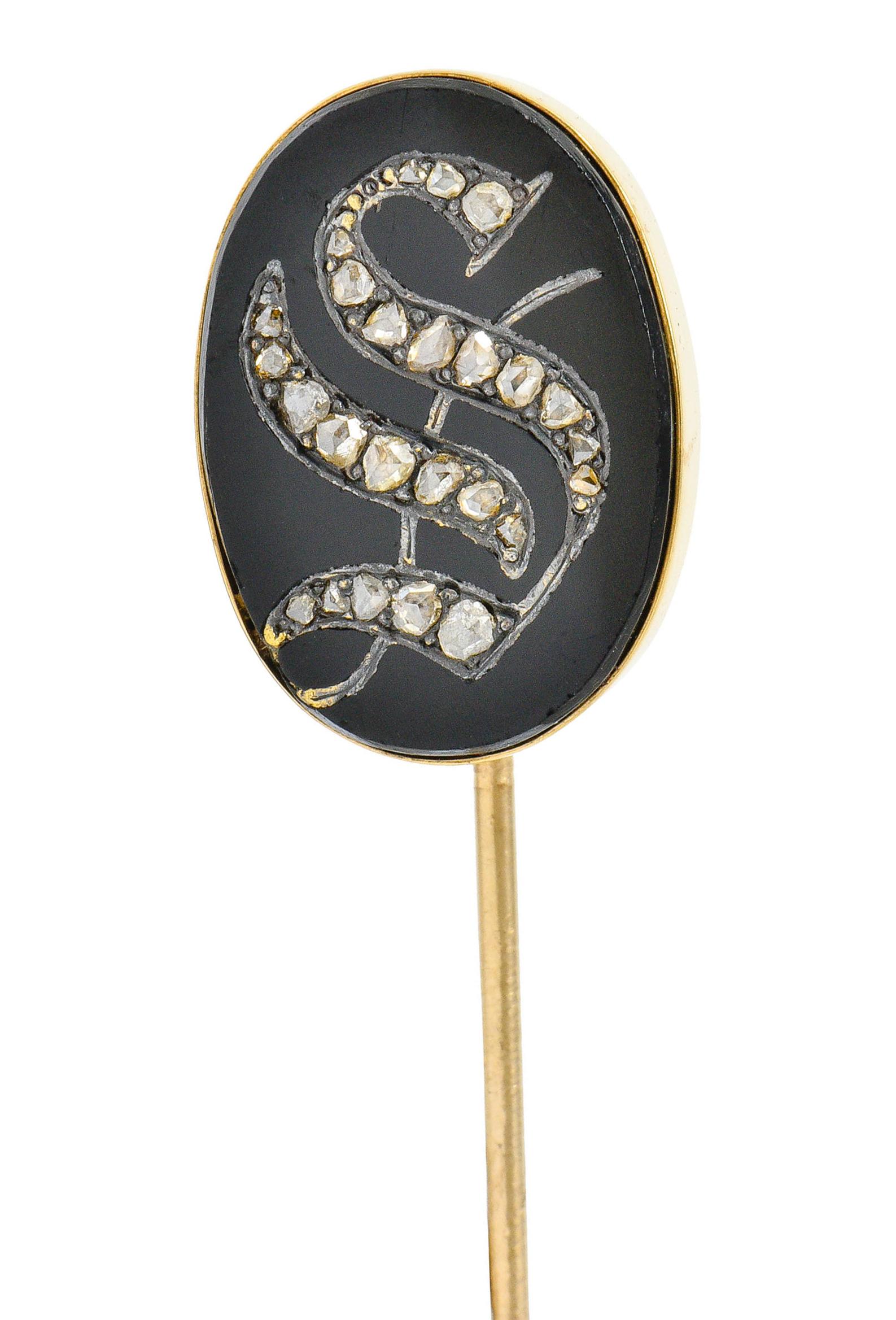 Centering an oval tablet of polished black onyx measuring approximately 18.5x 13.0 mm

Deeply carved to depict a stylized monogramed 'S' accented by rose cut diamonds

Bezel set in a polished gold surround

Tested as 14 karat gold

Circa: