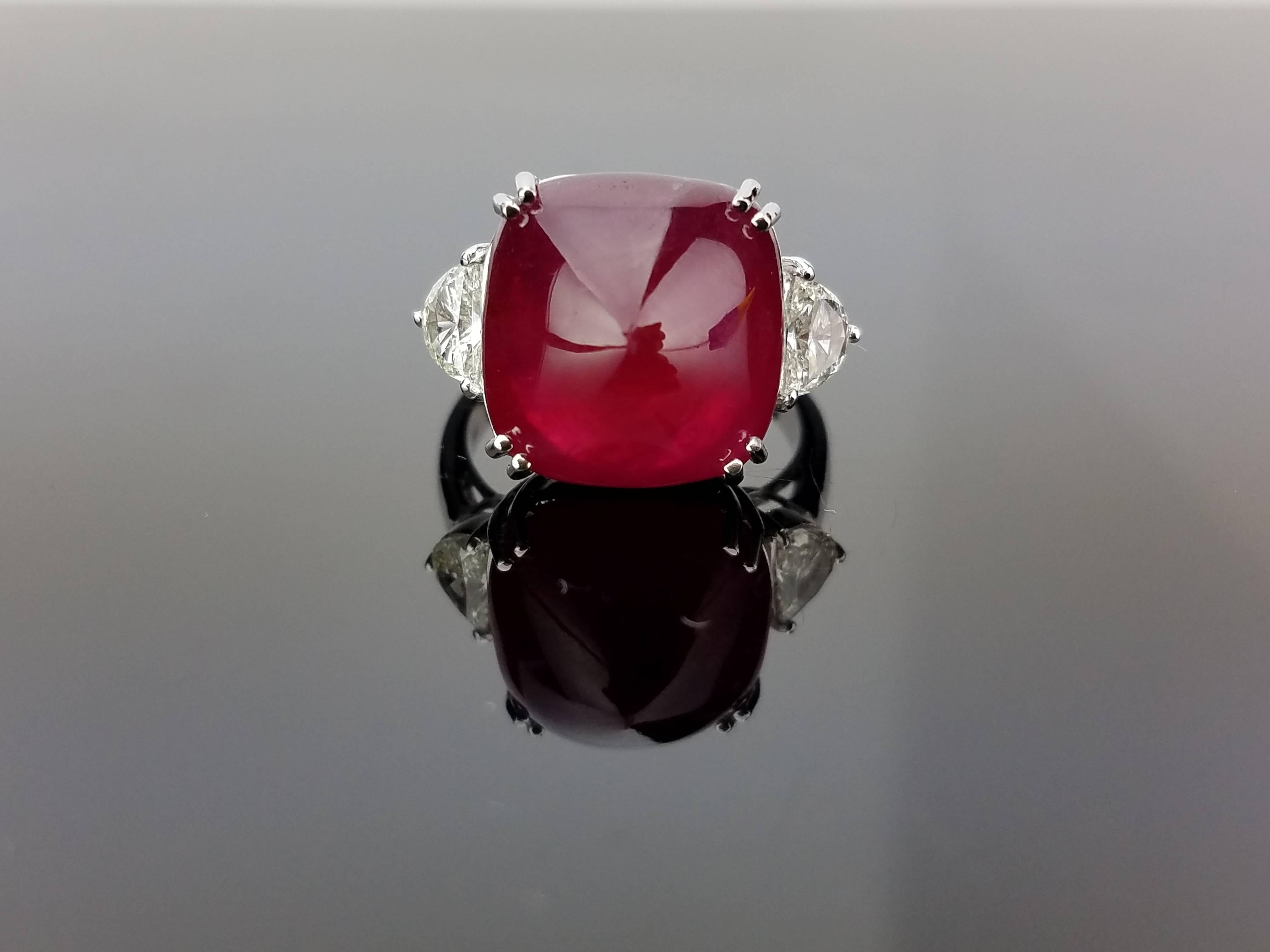An elegant cocktail ring using a sugarloaf African Ruby centre stone and two half-moon diamond side stones, all set in 18K white gold. 

Stone Details: 
Stone: African Ruby
Carat Weight: 18.62 Carats

Diamond Details: 
Total Carat Weight: 0.61