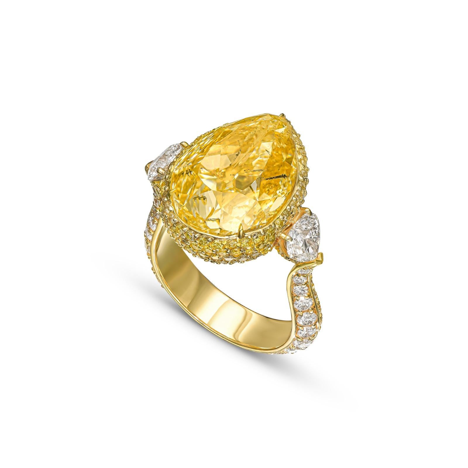 Préparez-vous à être enchanté par cette exquise bague de fiançailles à halos en or jaune 18 carats, véritable incarnation du romantisme et de l'élégance. En son cœur se trouve un époustouflant diamant poire de 14,37 carats de couleur jaune clair, de