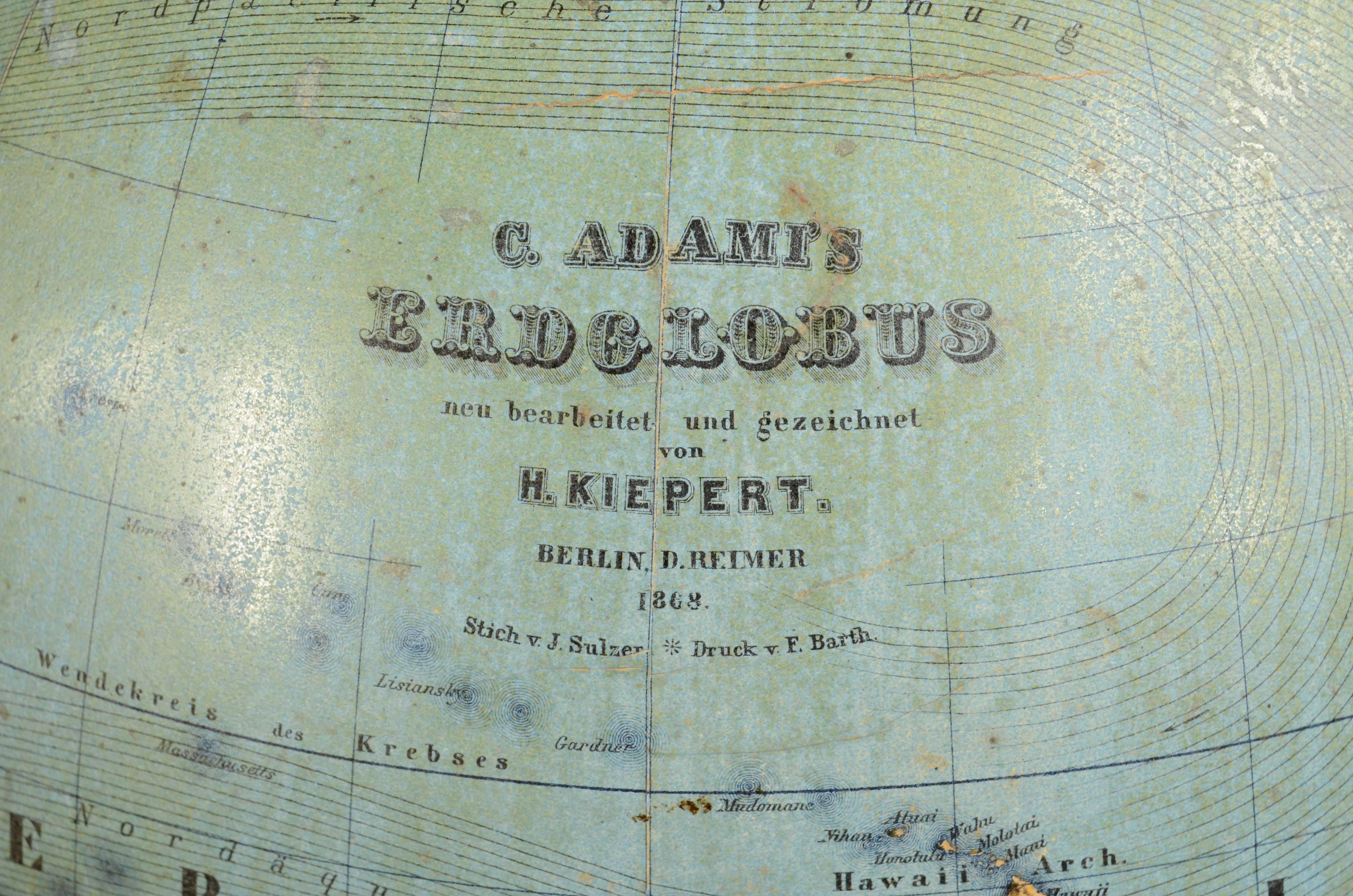 Globo terrestre  edito nel 1868 da Verlag Dietrich Reimer dal cartografo Carl Adami. Base tripode a cestello in legno ebanizzato con  bussola alla base, sfera in carta pesta e gesso rivestita di carta da incisione su lastra di rame. Oltre alla mappa