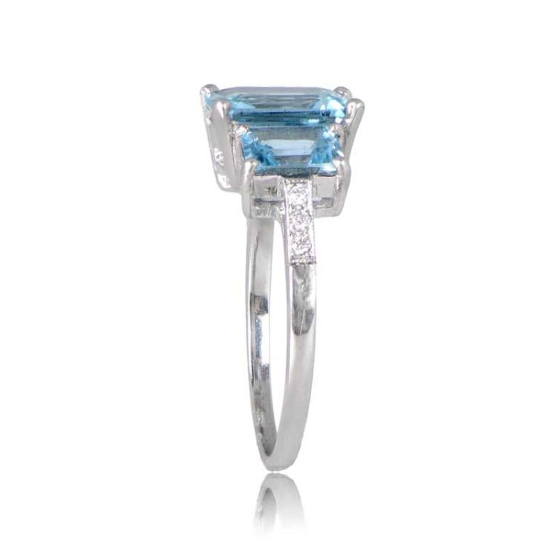 An exquisite three-stone aquamarine engagement ring showcasing a vibrant 1.86 carat step-cut aquamarine at the center. Flanking the main gemstone are two step-cut side aquamarines with a combined weight of 1.05 carats, boasting matching teal