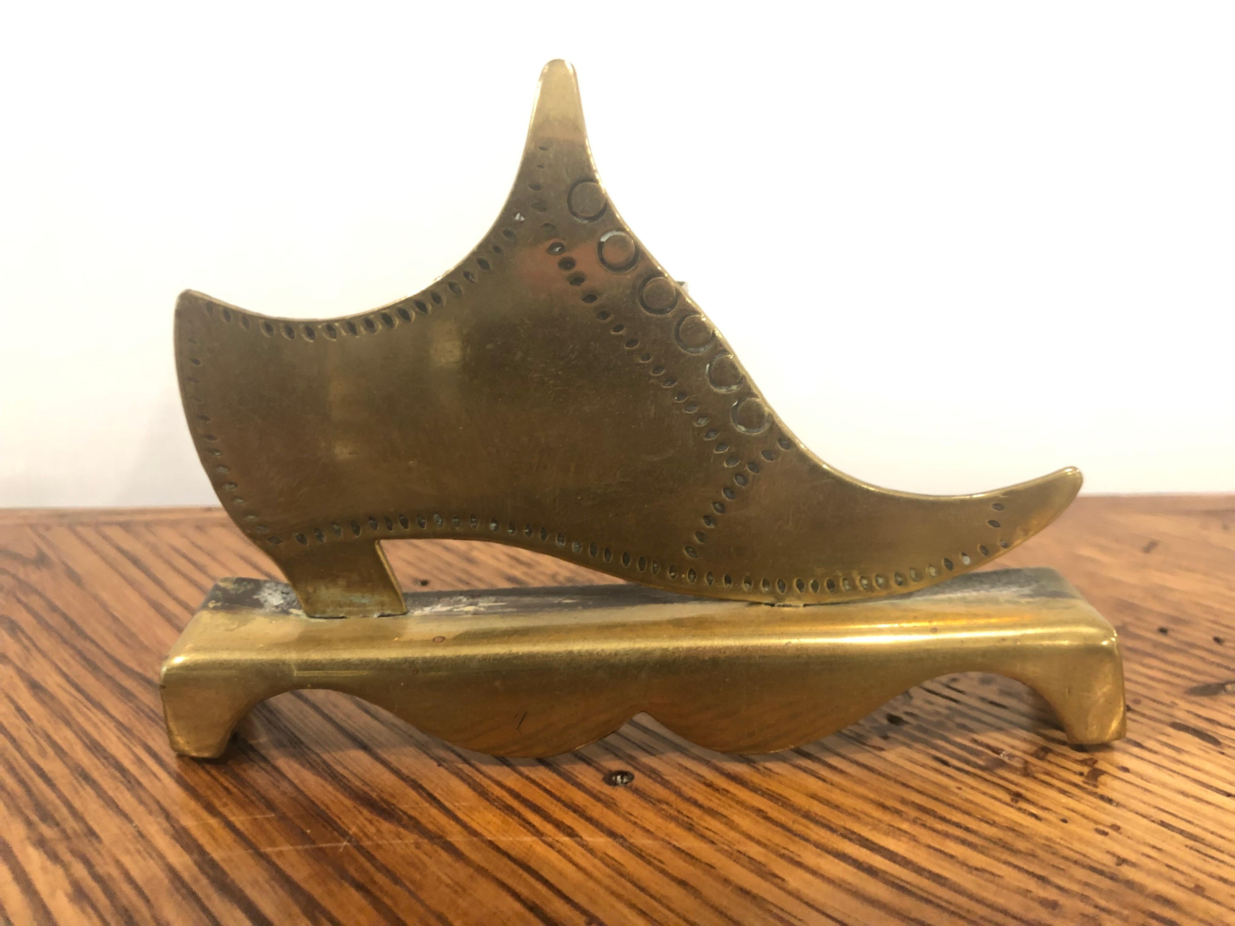Late 19th century solid brass 1870 English single shoe spill vase with incised detail and a rear holder from a private collector who traveled the world buy and selling beautiful items.