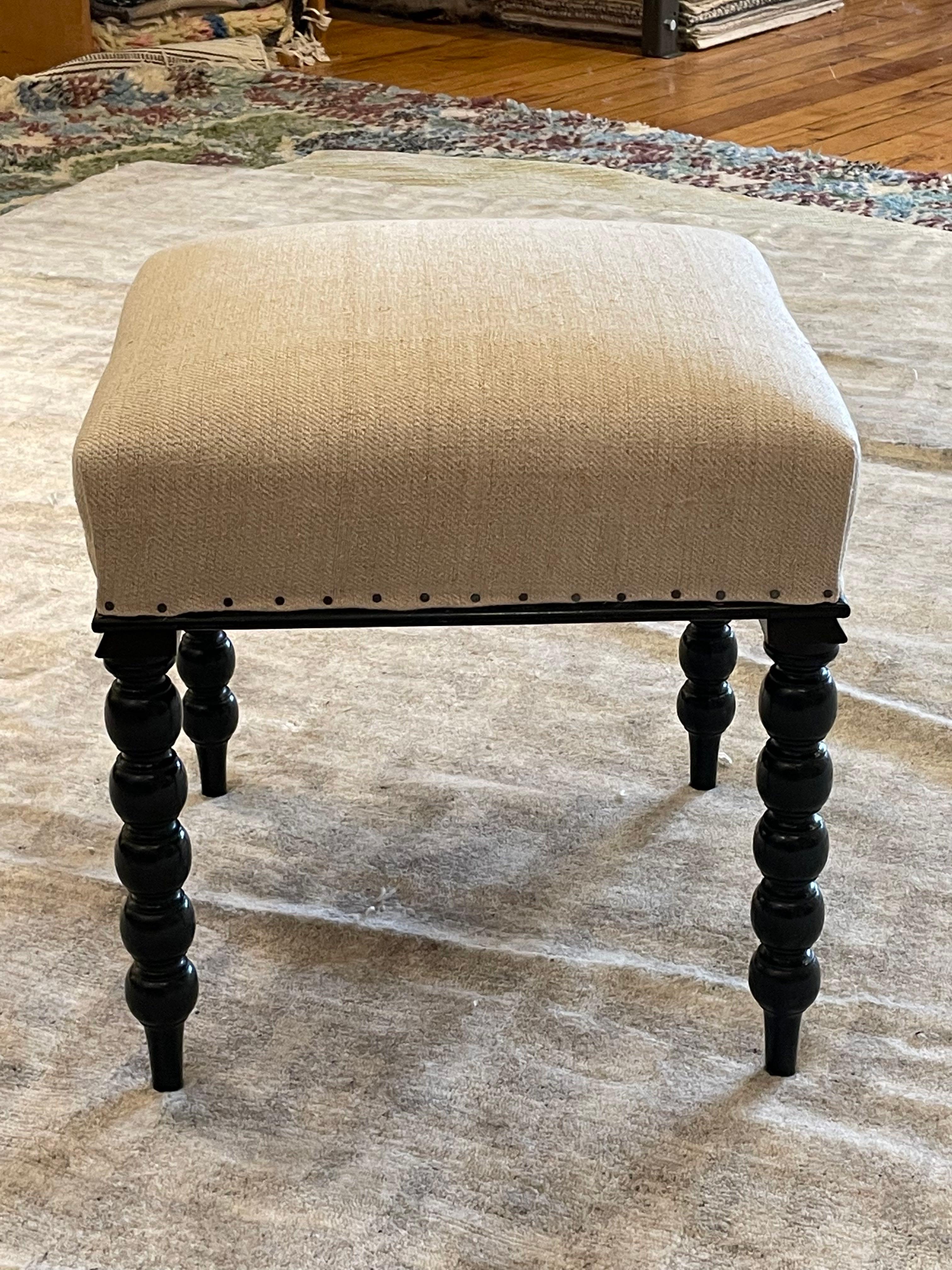 1870c English ebonized square shaped foot stool.
Four bobbin turned legs, finished on a raised turned toe.
Recently reupholstered in vintage hand spun Belgian linen.