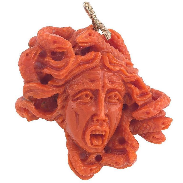 The Mediterranean Sea coral carved to depict an impressive Medusa with the face encircled by snakes.

At the top the gold snake shape hook.

Dimensions: 58 mm high (including the hook), 55 mm wide (at the largest point)