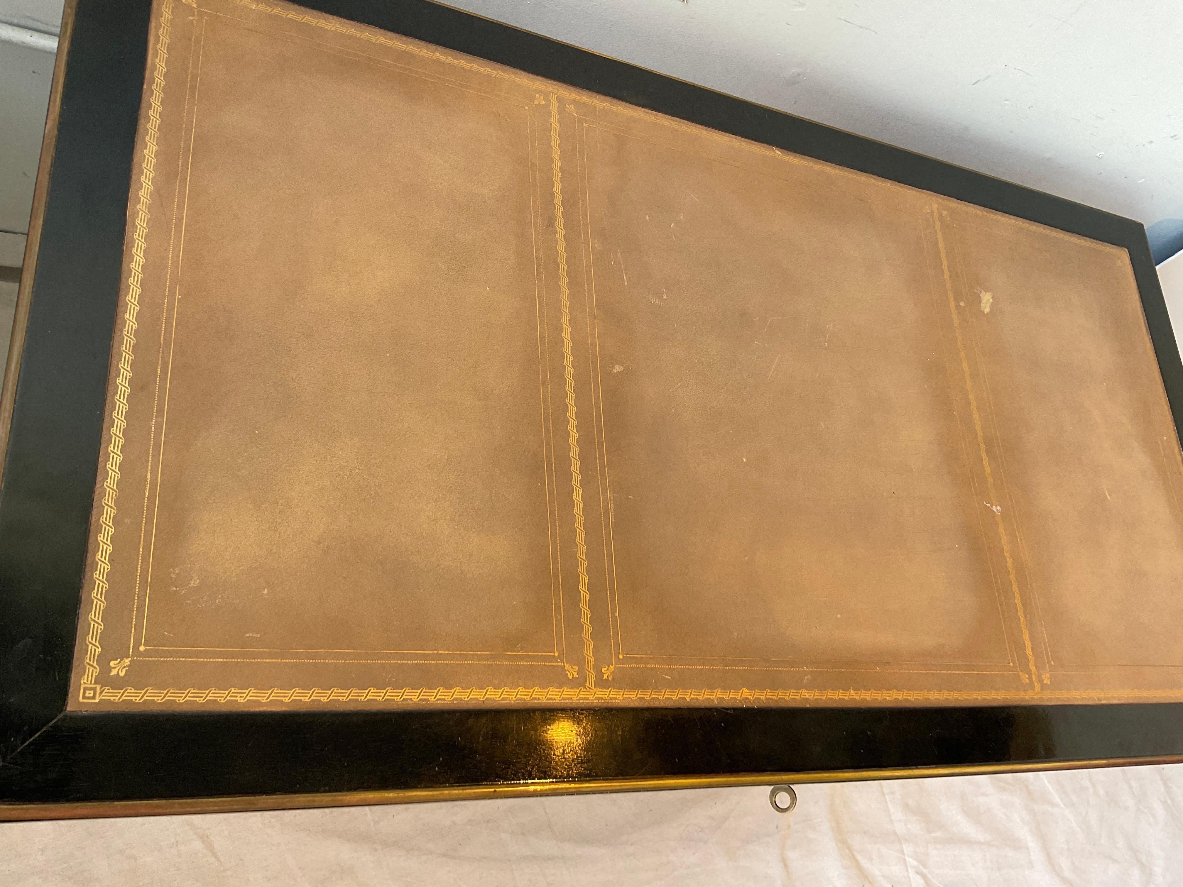 Scrivania francese del 1870 con piano in pelle ebanizzata e accenti in ottone. La parte superiore in pelle presenta punti usurati, come mostrato nella foto.