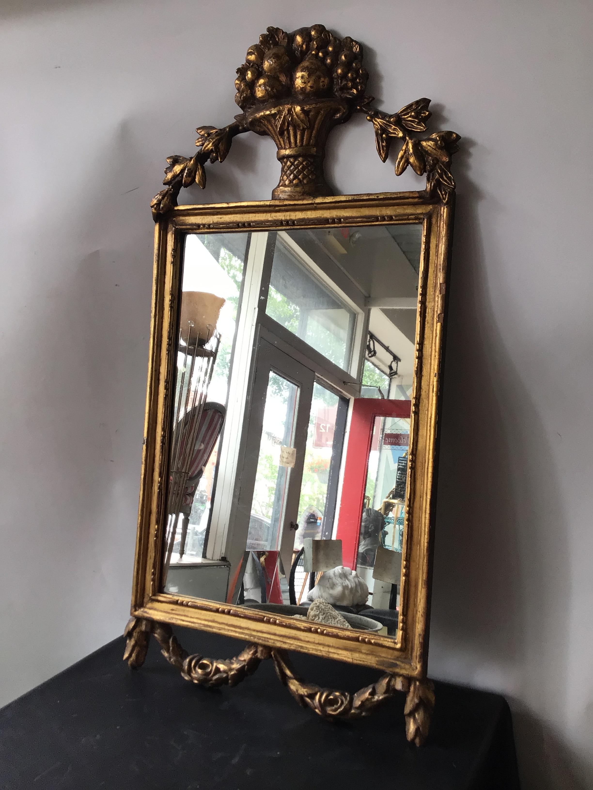 1870s French hand carved gilt wood mirror adorned with basket of flowers.