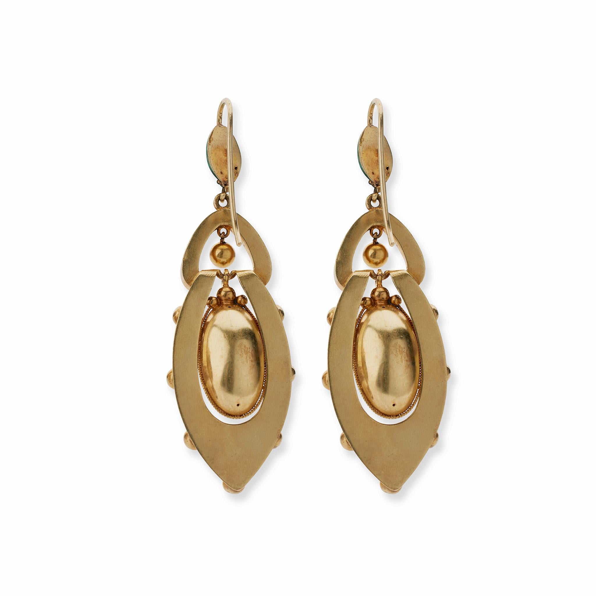 These pendant earrings in 14K gold, enamel and diamond were created in the 1870s, possibly in England. Each flexible multi-tiered form is designed as an oval top suspending an elongated elliptical form with ball and wirework accents framing a