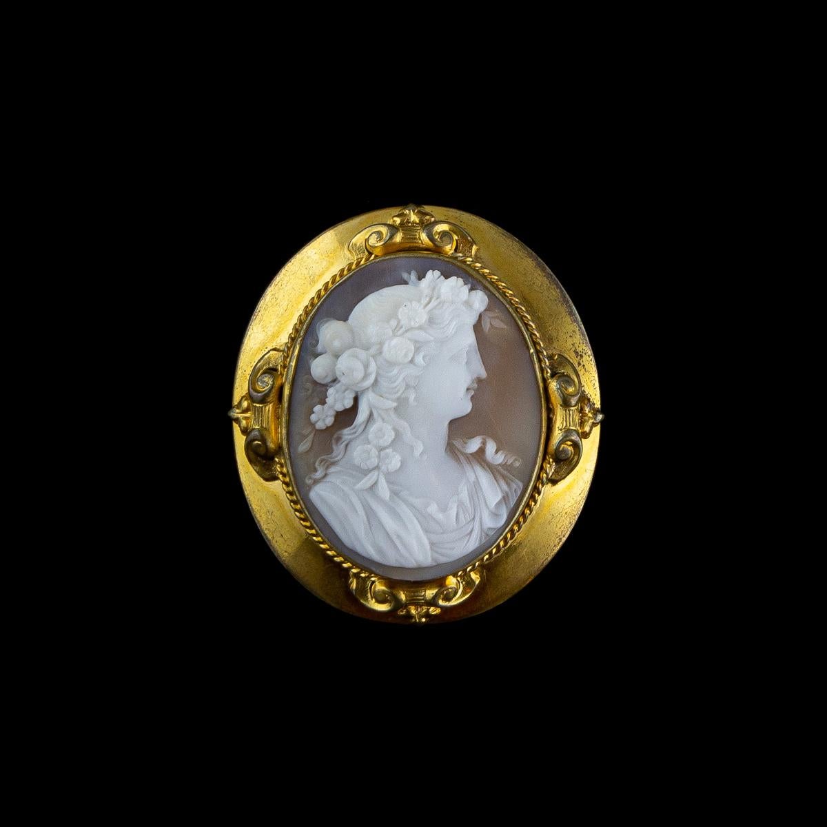 1870s antique brooch in gold-finish metal with a shell cameo depicting a female profile with a delightful hairstyle with flowers. Cameo set in a carved and engraved setting.
An ancient jewel is much more than its intrinsic value, in gold, silver and