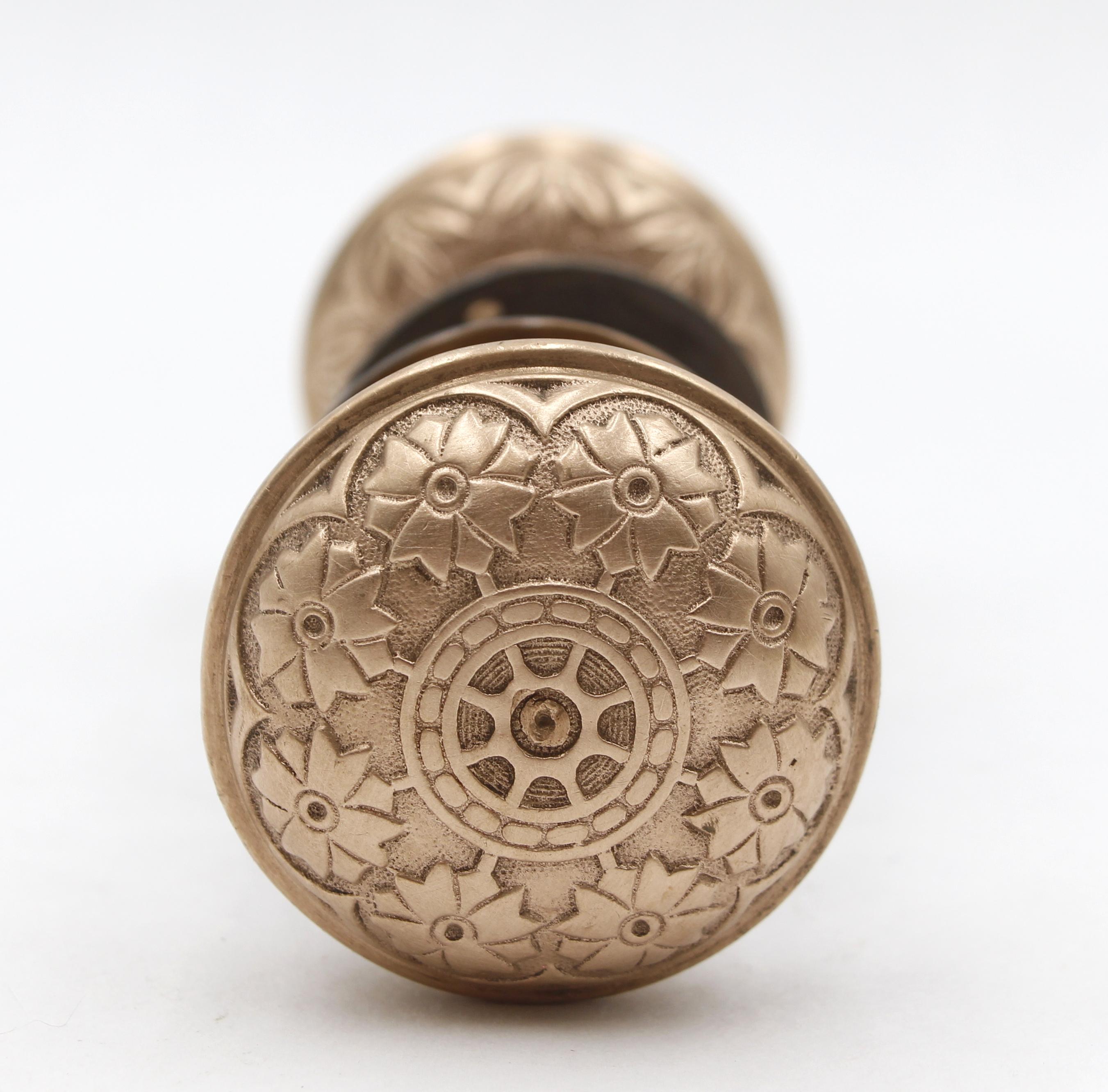 These Vernacular door knobs were made by Hopkins & Dickinson in the 1879 catalog. It is part of the K-21300 group. The ornate brass rosettes are newly made. The rosette mounting screws are included. Priced as two door knobs, two rosettes, and a