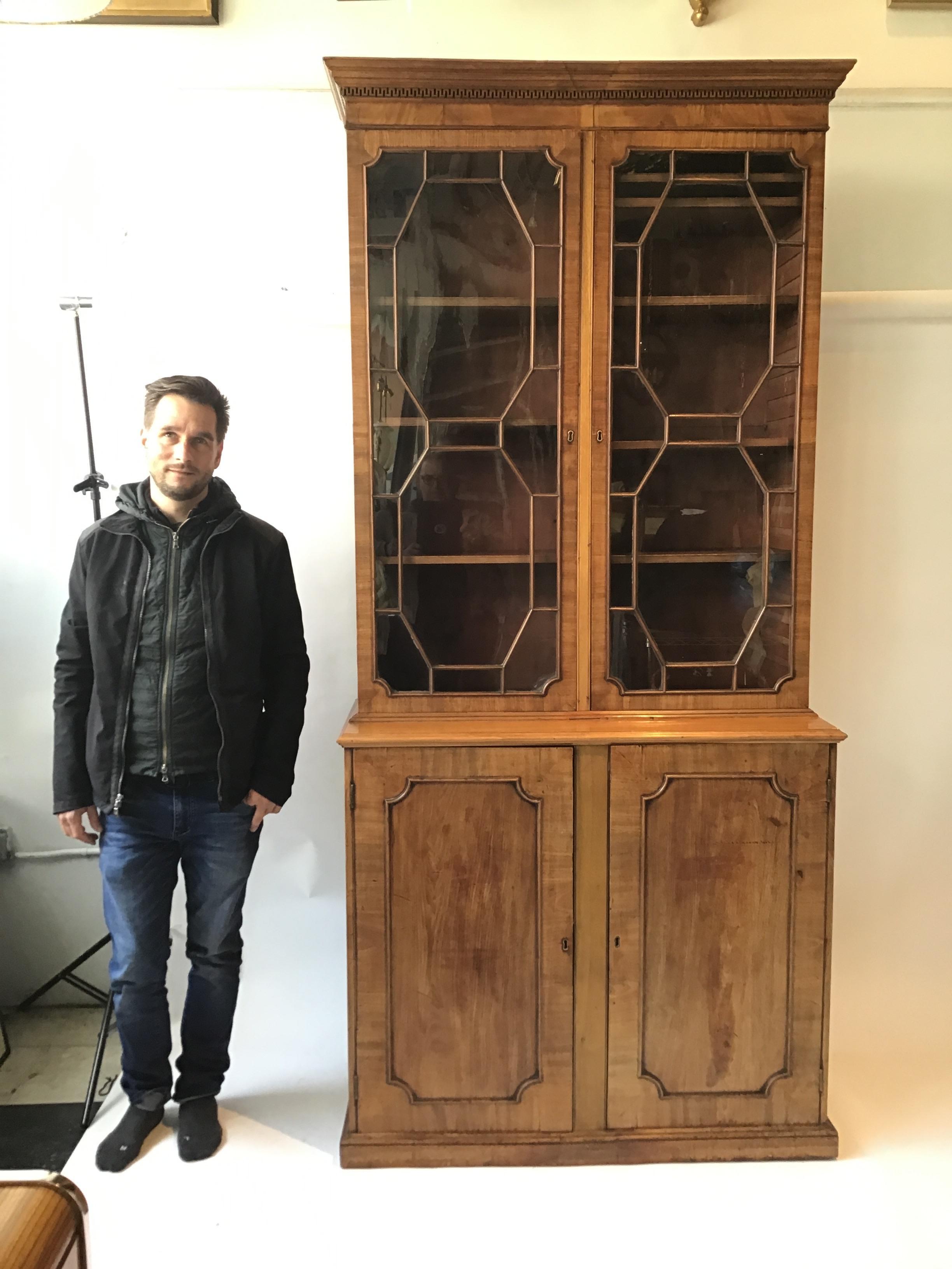 1870s tall English Regency 2 glass door cabinet. Each pane of glass is separately placed into the molding. There are a total of 30 panels of glass. Old, wavy glass. Measure: ( 91”).
Cabinet is 2 pieces.