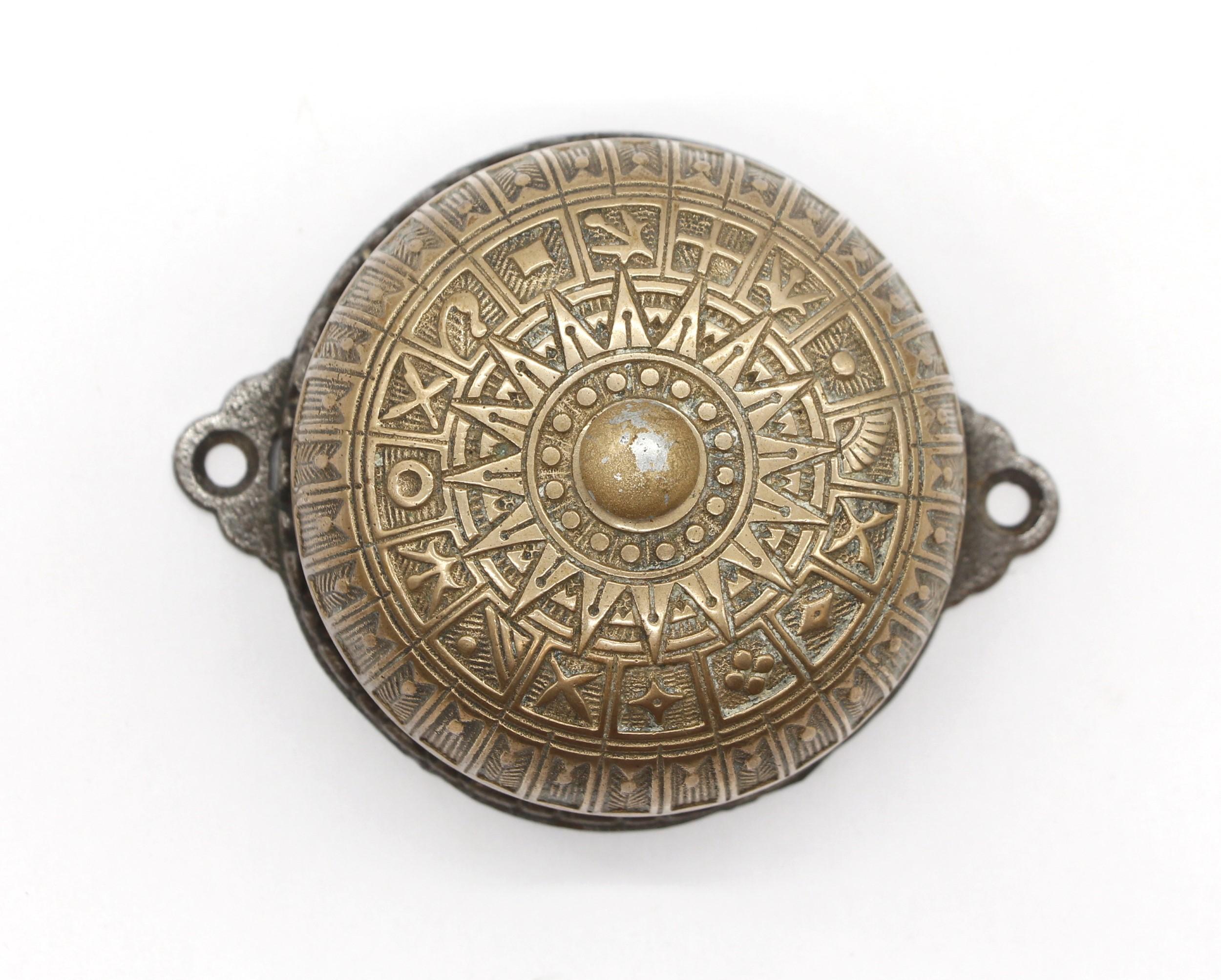 This ornate polished bronze doorbell comes complete with the pull down handle that operates the bell. There are date stamps for the patent in the back showing- July 2, 1872, April 1873 and July 4, 1878. This antique mechanical doorbell is still in