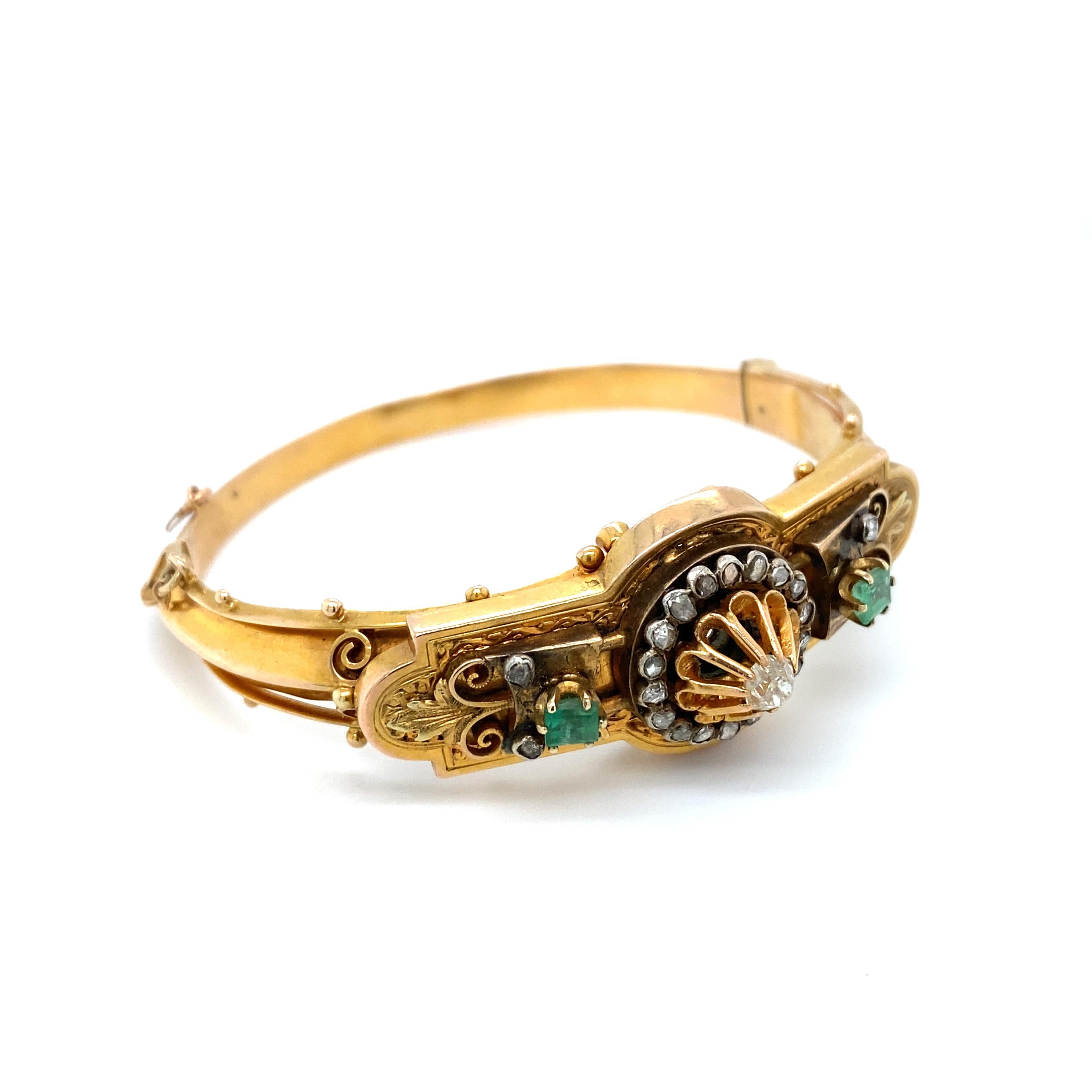 Item Details: This Victorian era hinged bangle bracelet is a high-quality piece that is over 140 years old. With its brilliant diamonds and emeralds and intricate detailing, this bracelet is a hallmark of Victorian era design. It is a beautiful