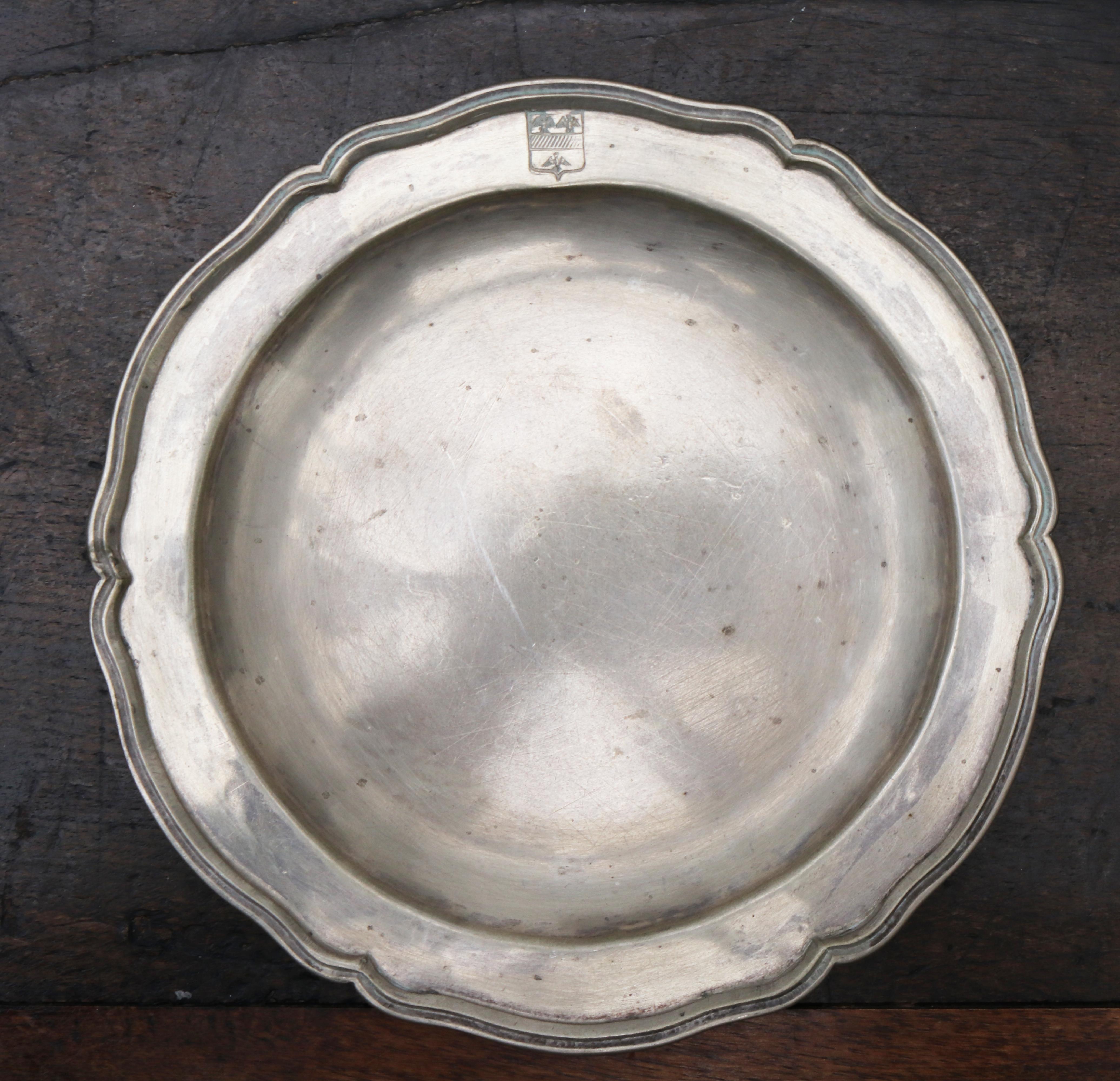1875 set of eight 90% silver plates with shaped edges and engraved crest. 

Silver by weight: 2310g.

 
