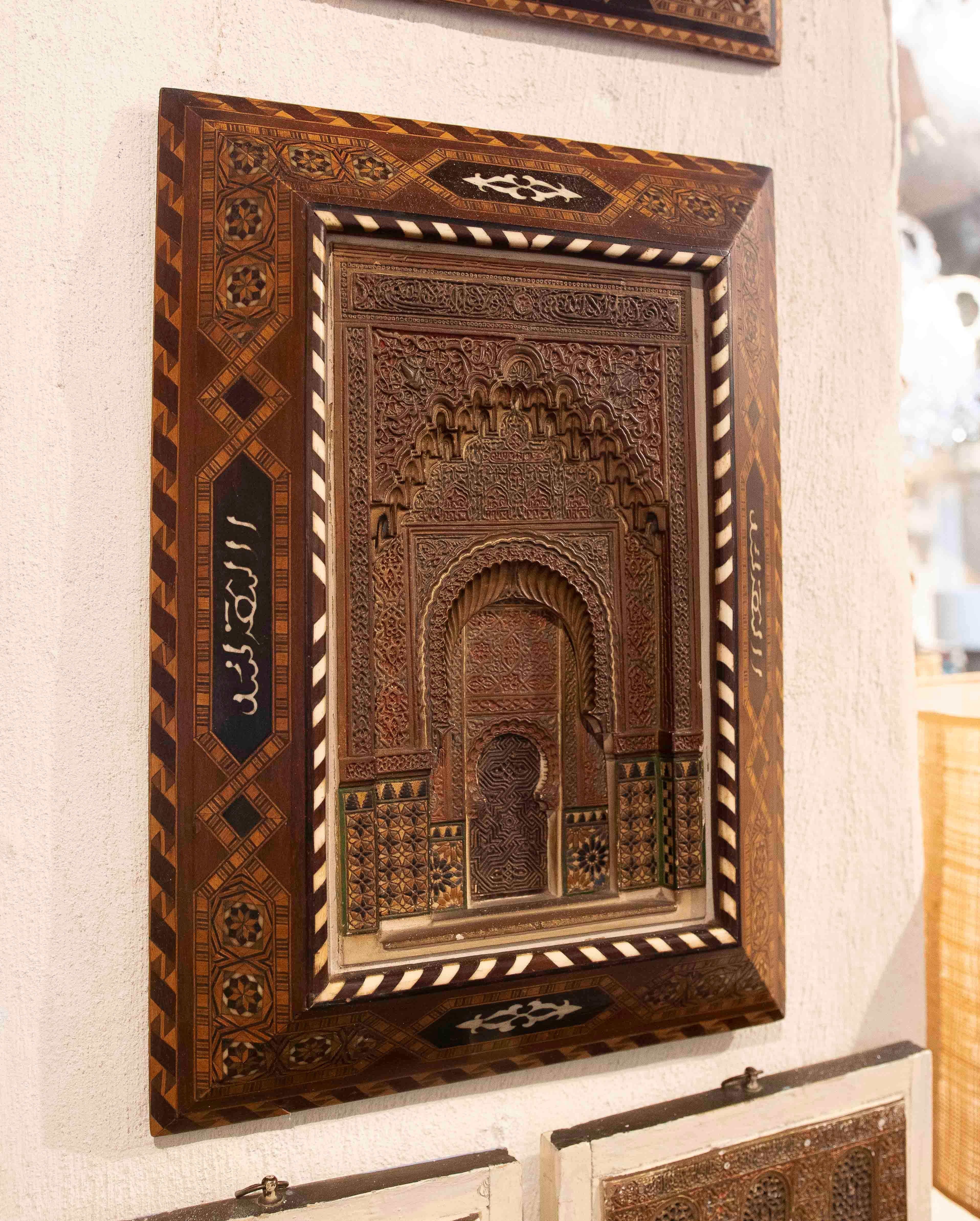 Magnífico relieve de madera tallada a mano, inspirado en la arquitectura y los motivos decorativos del arte árabe-andalusí. La pieza central presenta un arco de herradura ricamente ornamentado con intrincados detalles que evocan la majestuosidad de